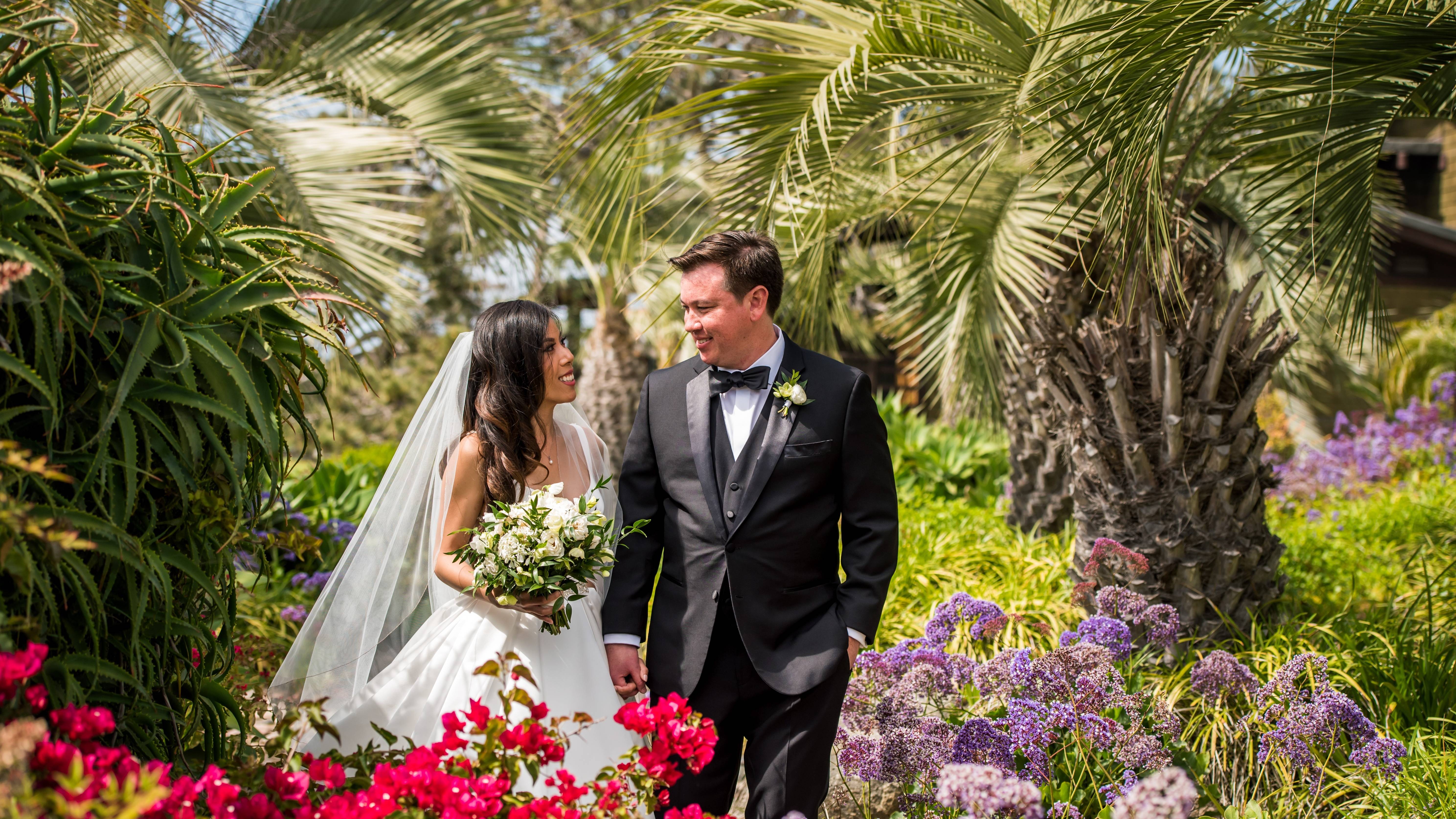 Bride and groom walking through hotel gardens