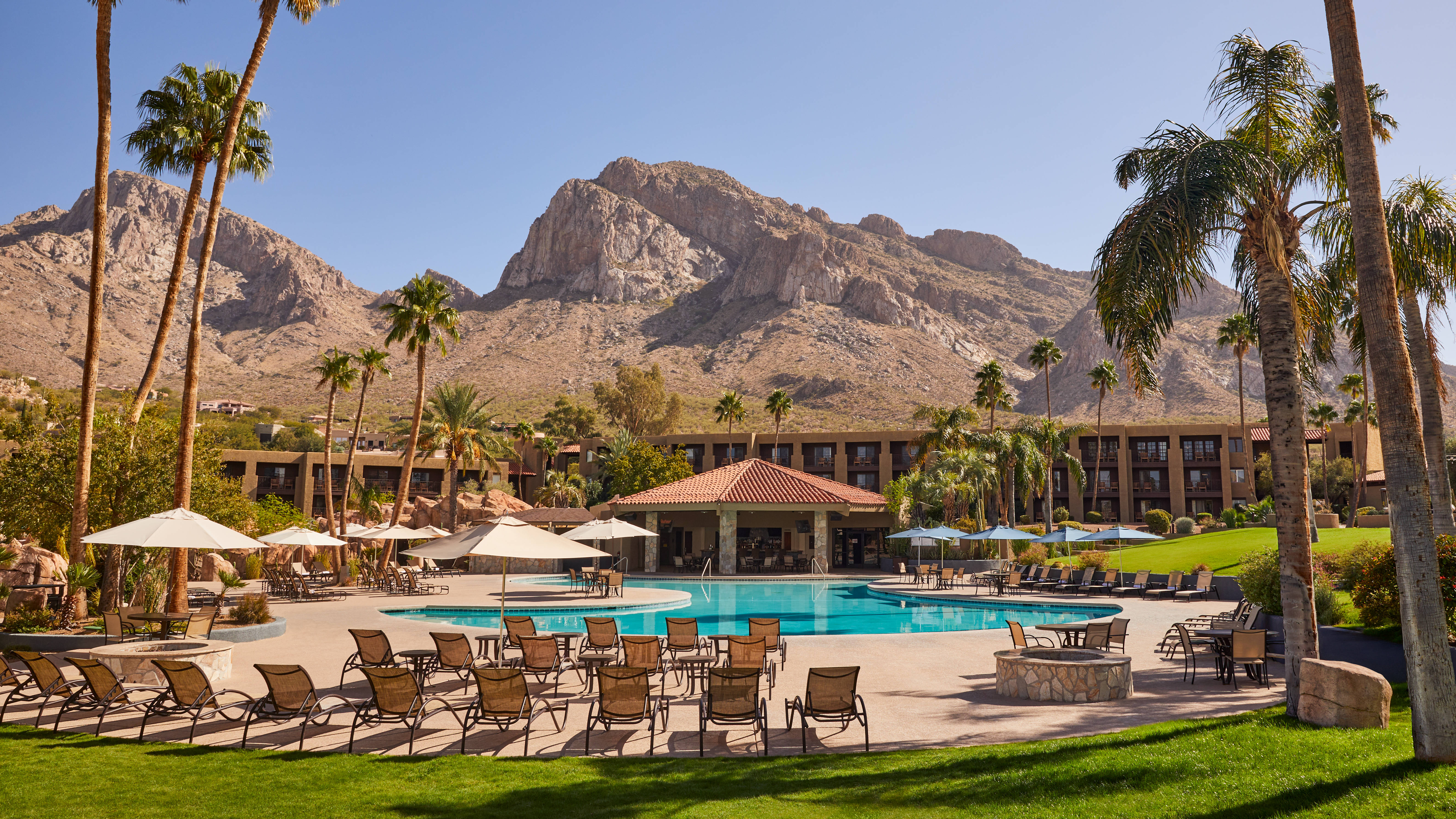 Main Outdoor Pool Area with Lounge Chairs, Palm Trees and Mountains in Background
