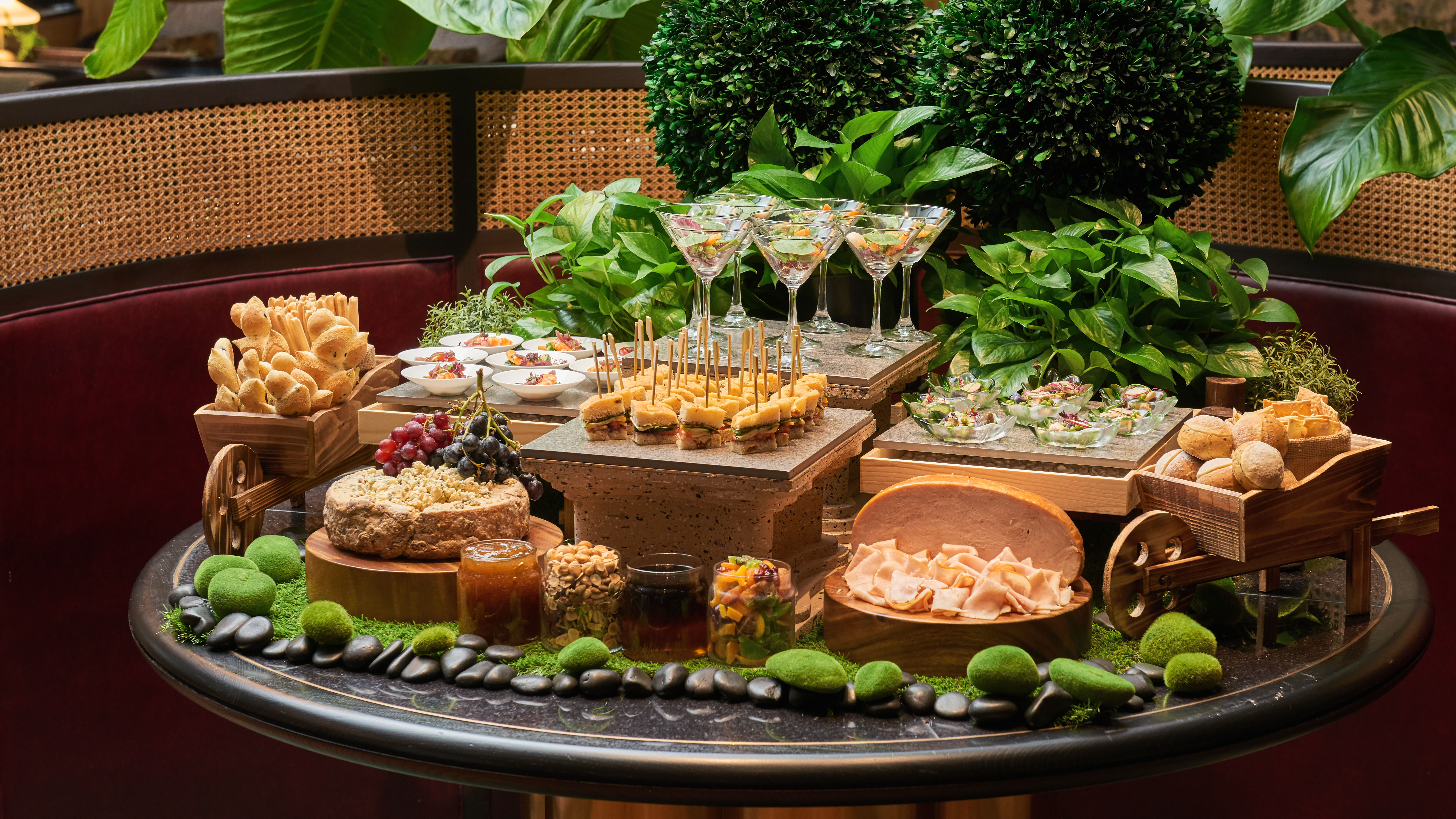 Selection of foods on a round table with foliage behind