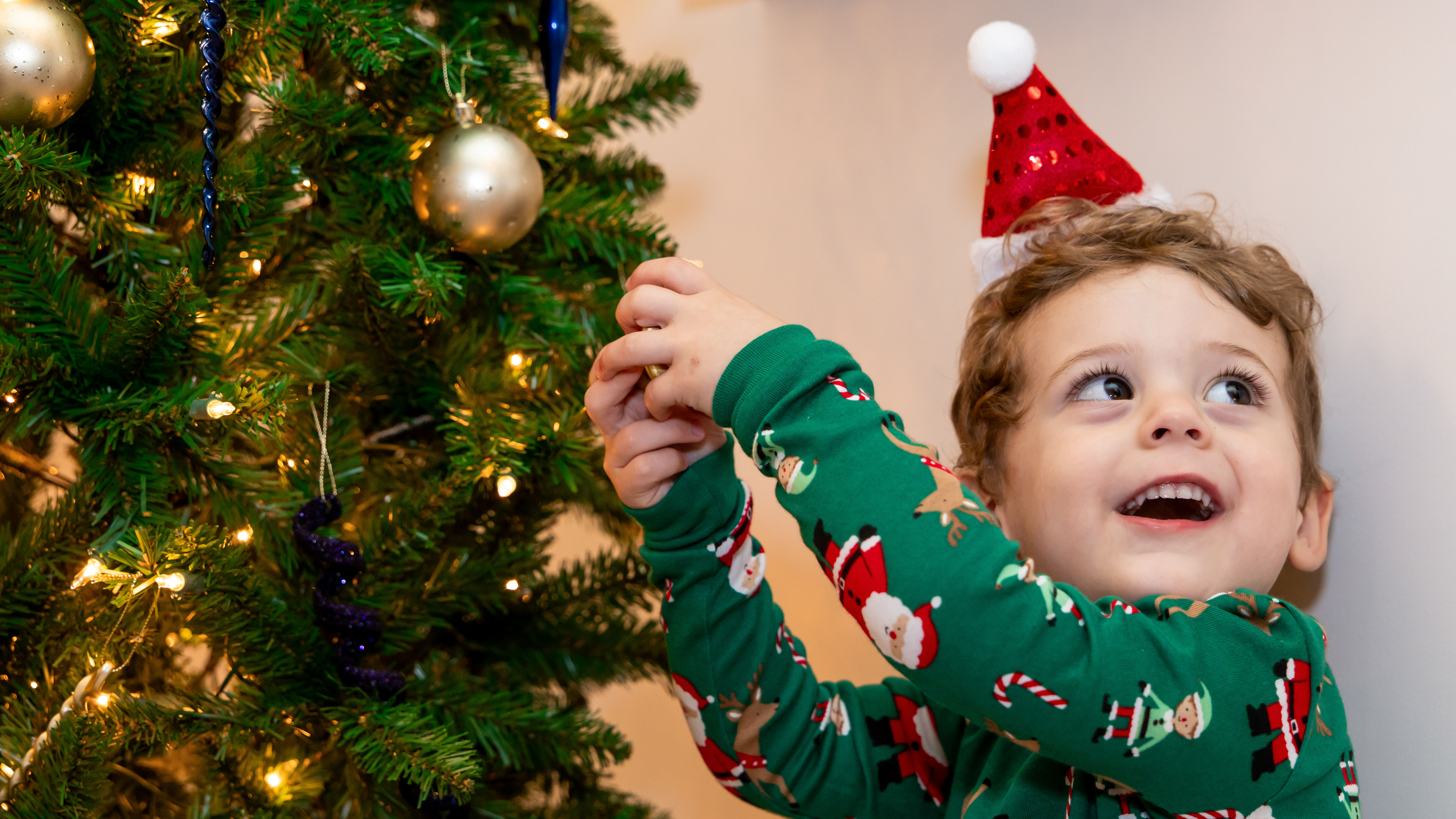 Kid next to Christmas tree