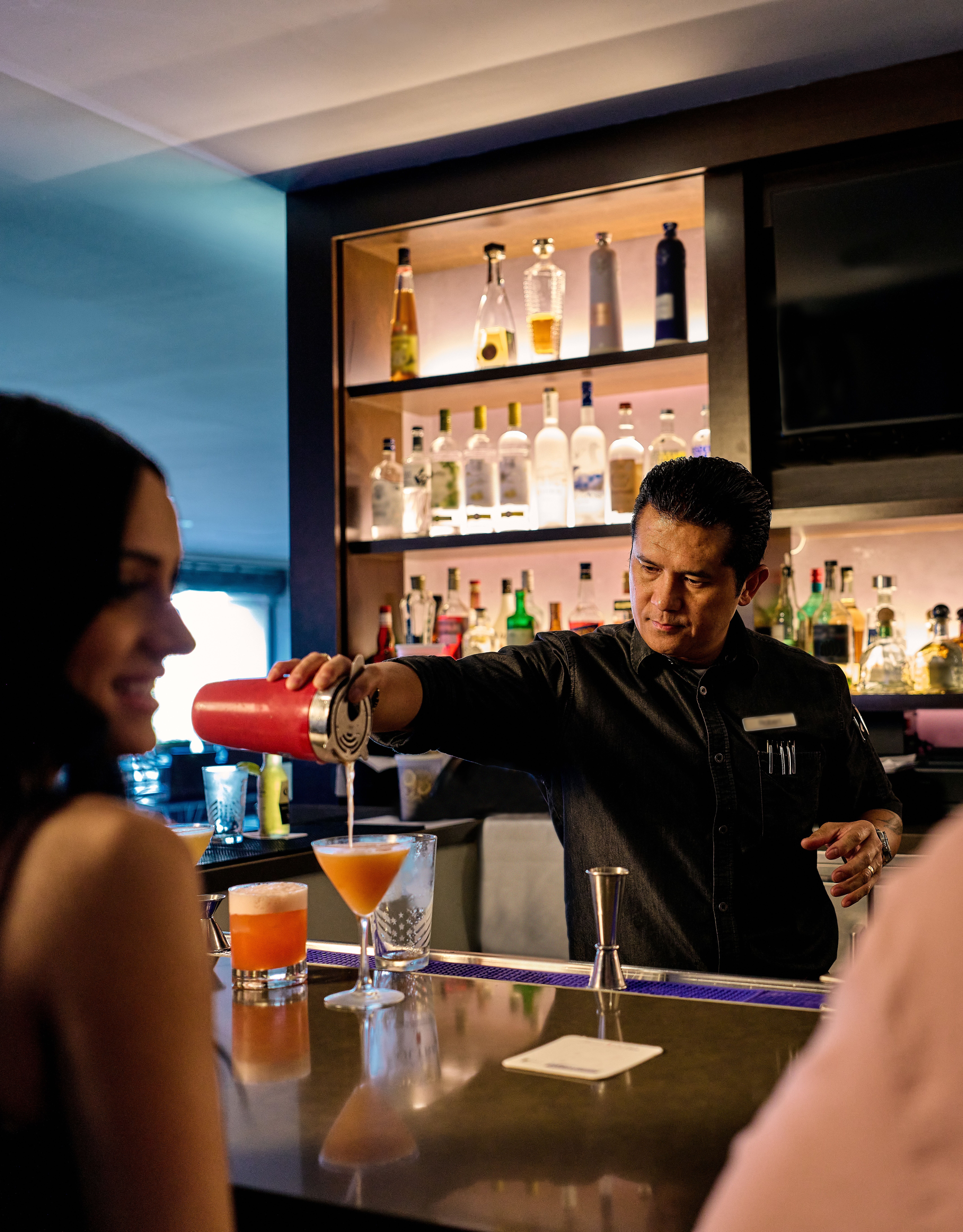 Bartender is serving cocktails to a couple at Cable 55 restaurant