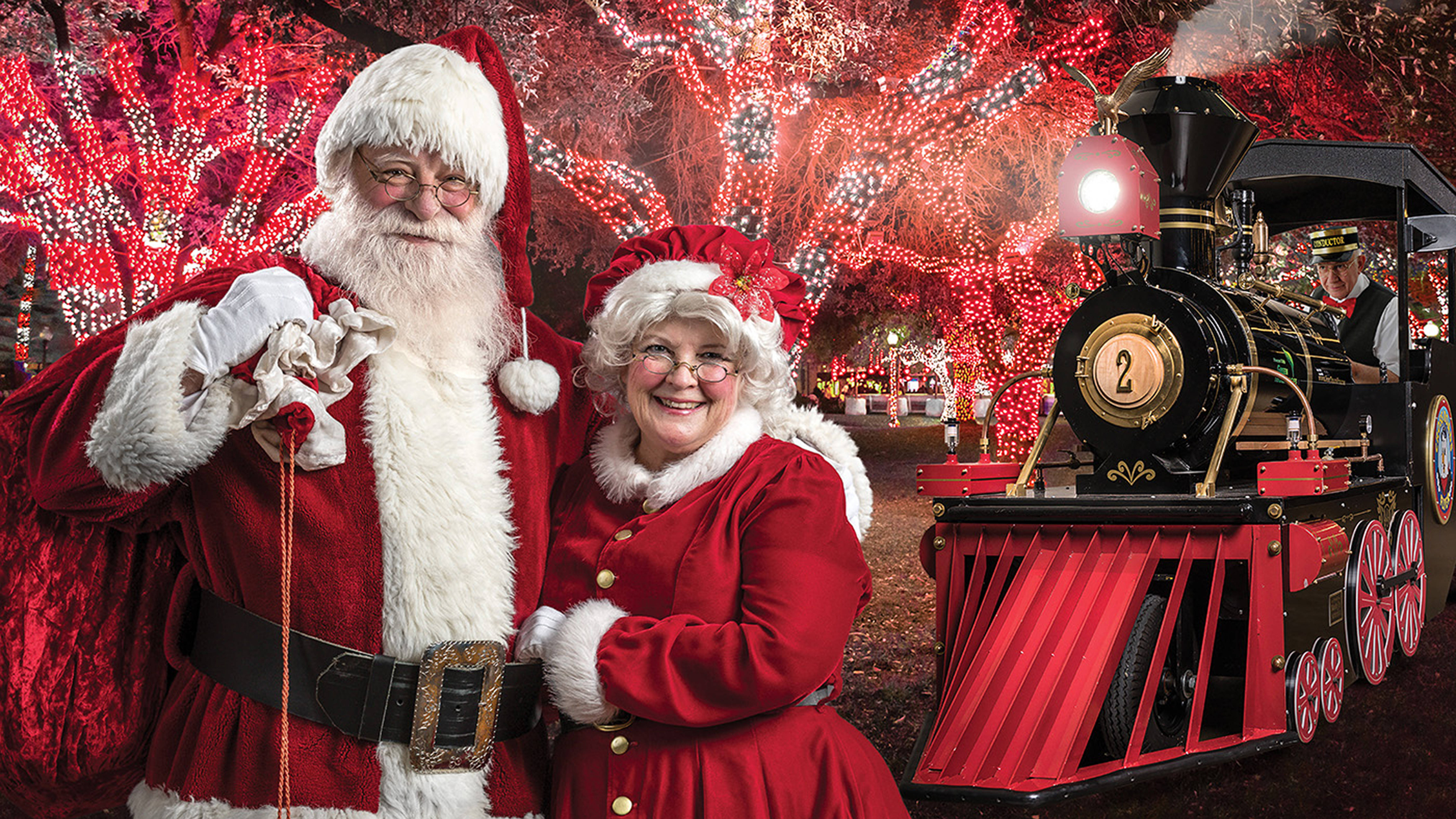 Image of Santa and Mrs. Claus with train and conductor in background