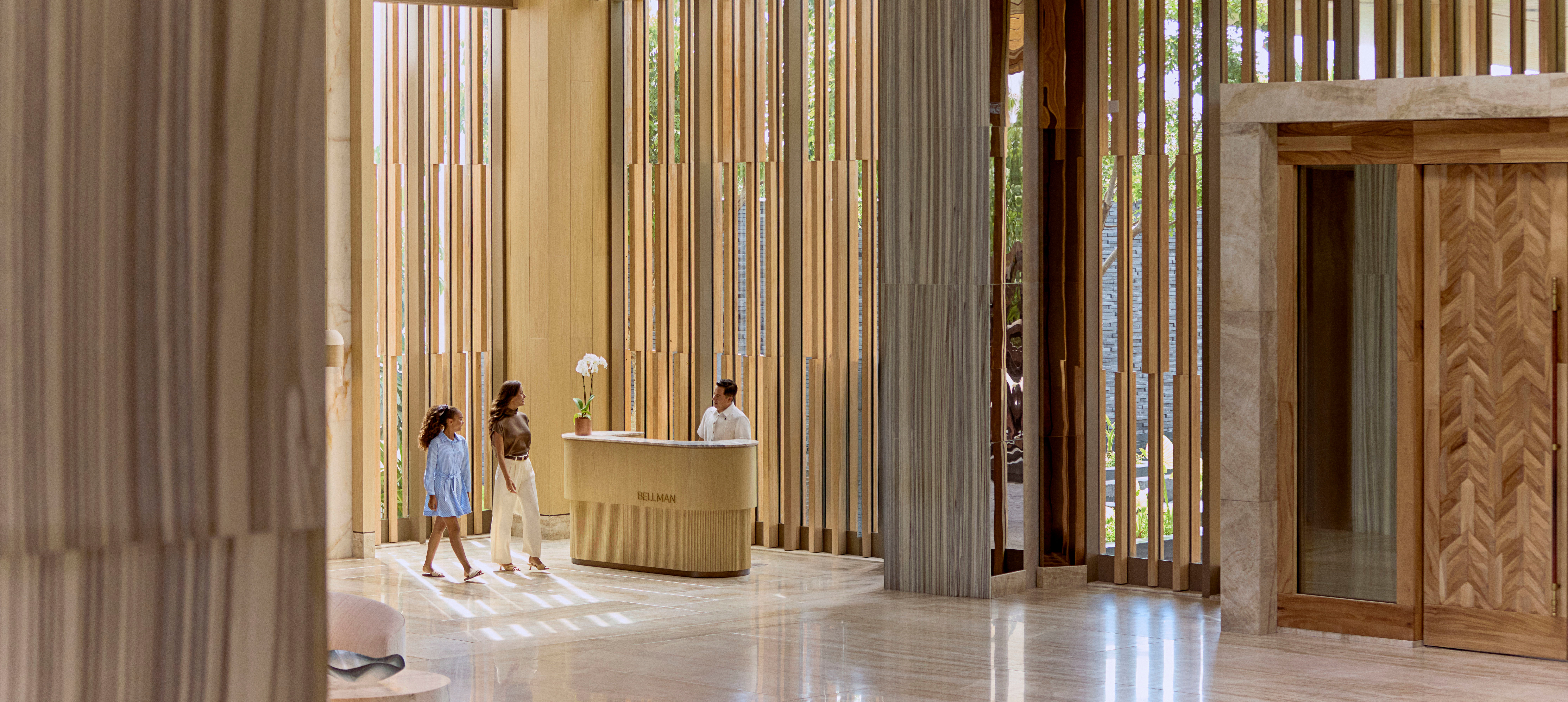 Mutter und Tochter gehen am Empfang des Hotels vorbei