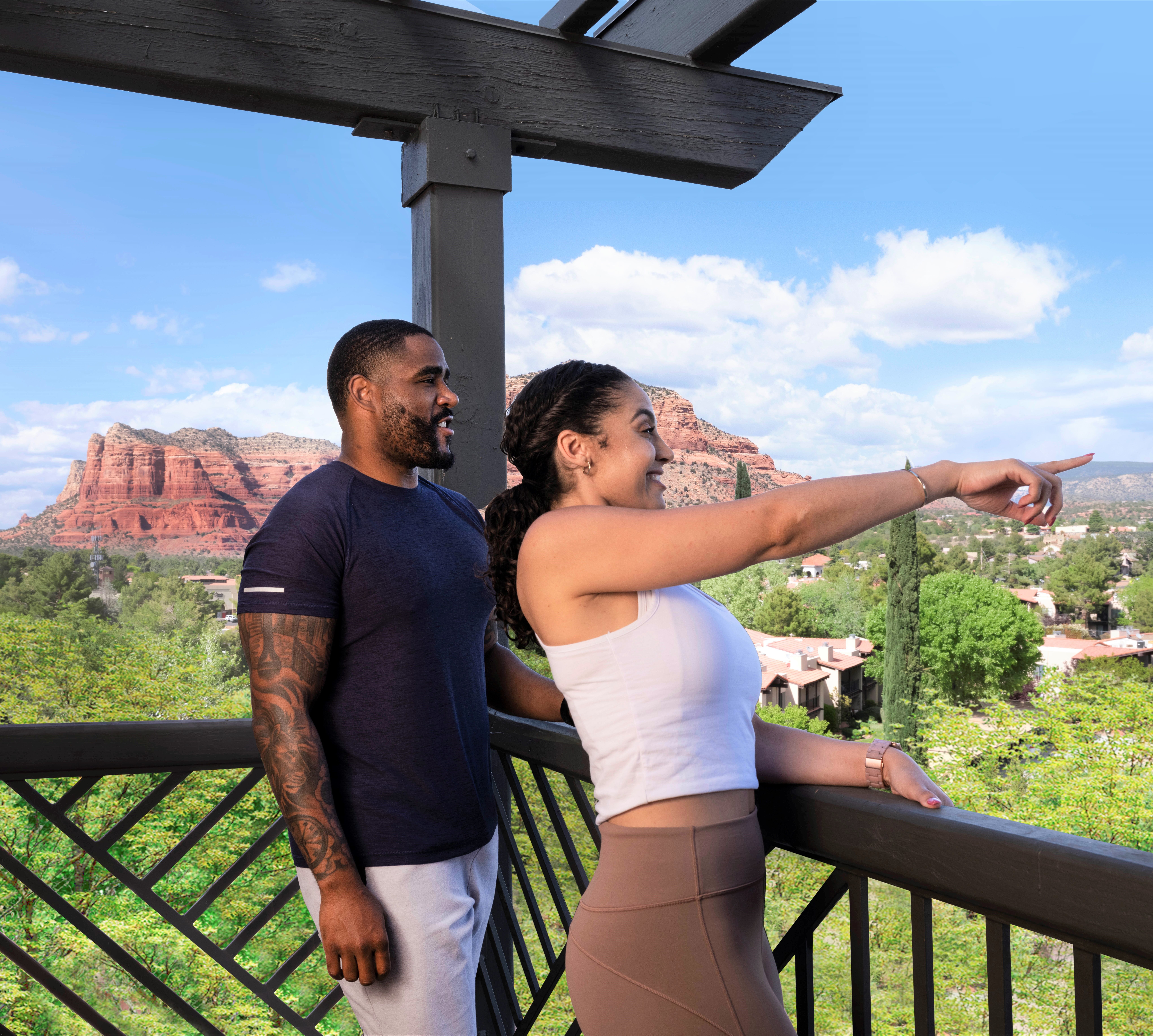 couple standing on balcony overlooking canyons