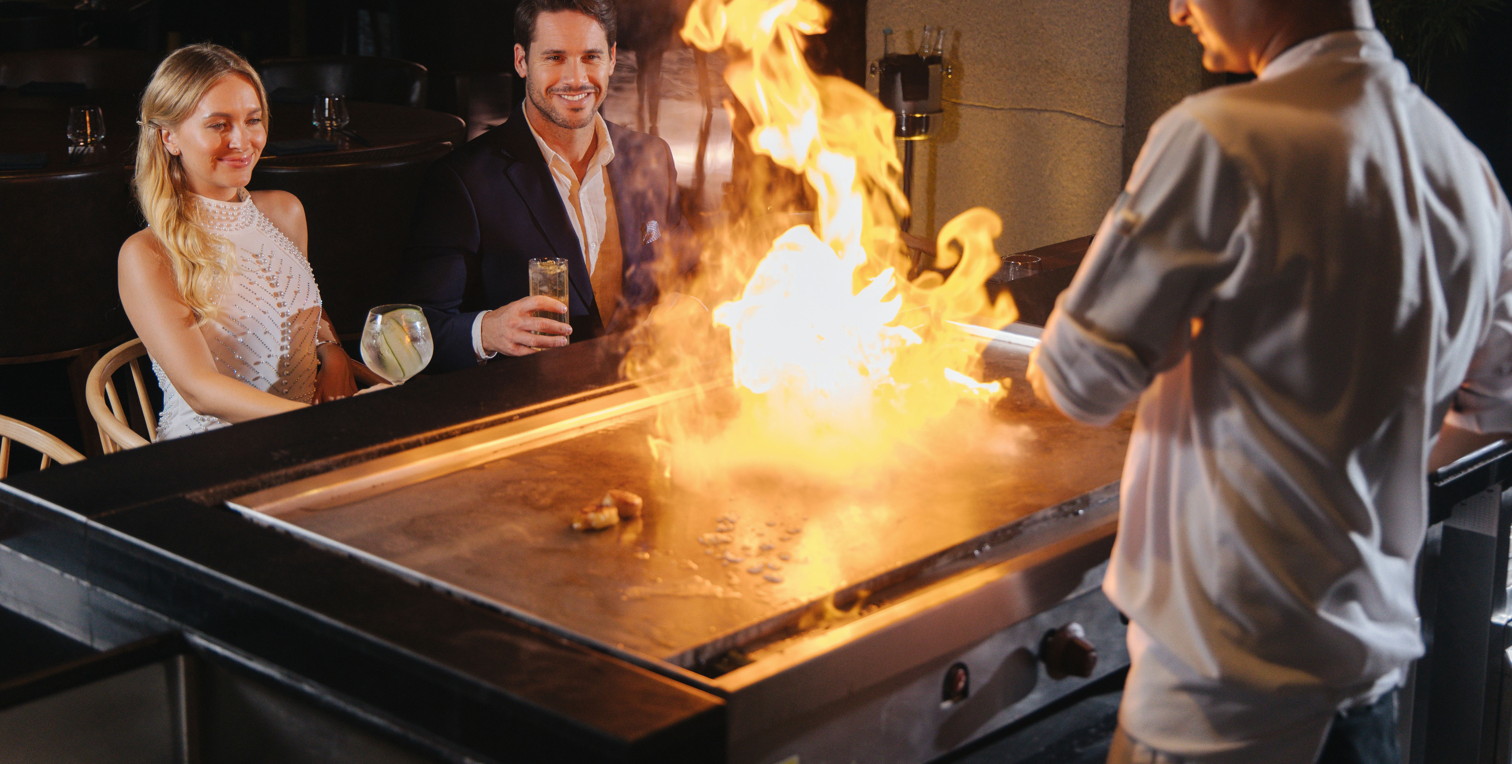 Couple Enjoying Watching a Chef Cooking on a Teppanyaki at UMI Restaurant