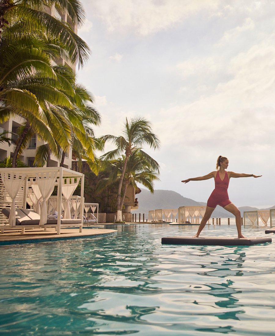 Guest practicing balance yoga on the oceanfront pool