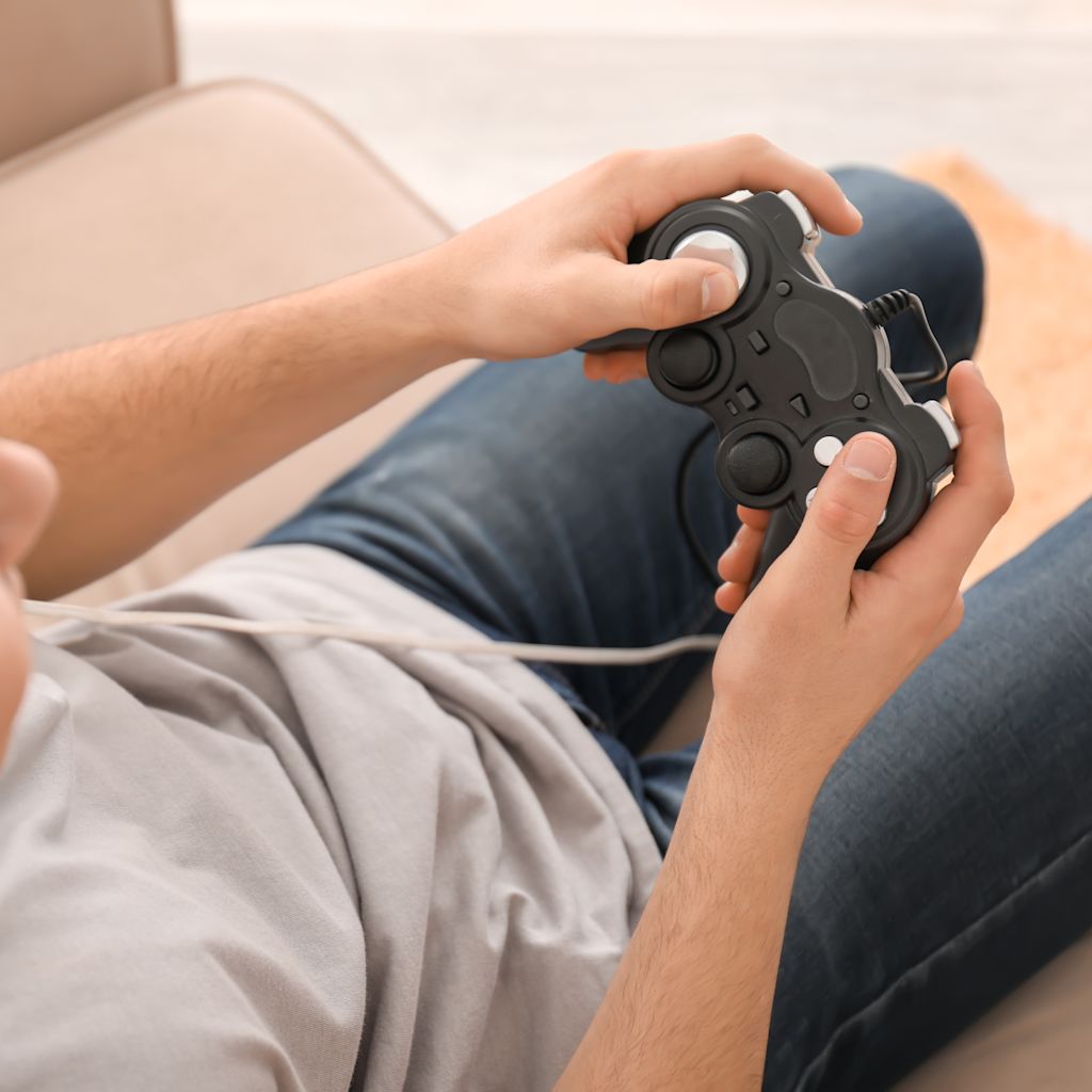 Boy sitting on chair wearing headset and holding game console controller