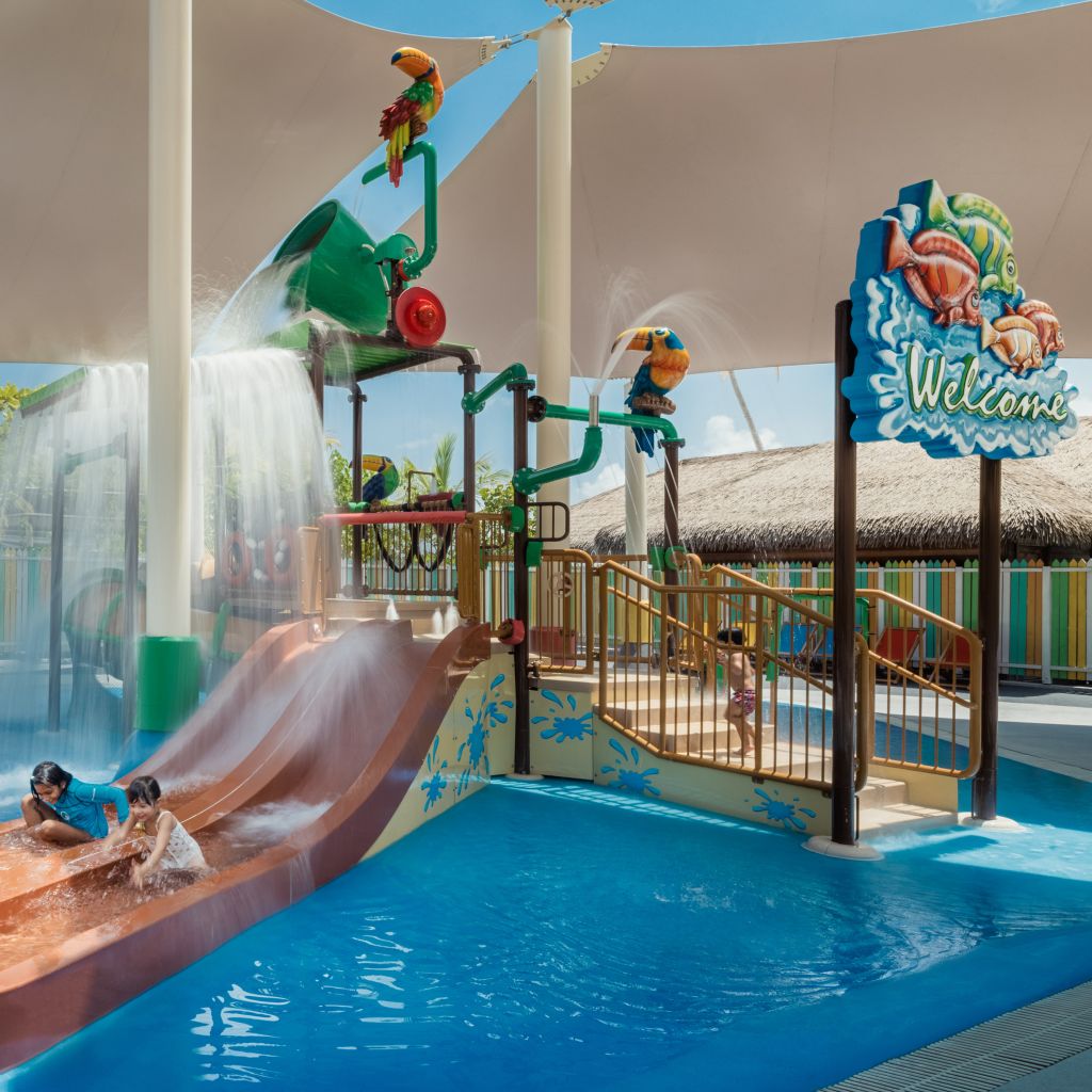 Pool area with children playing on water slides