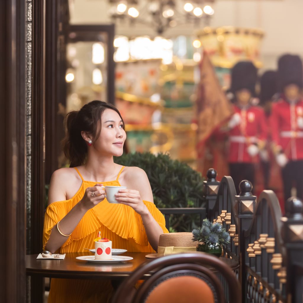 チャーチルズ・テーブル・レストランのテラスでコーヒーを飲む女性