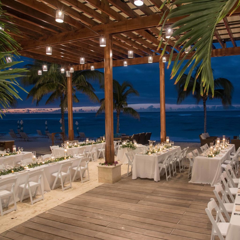 Wedding table setup under beach hut with ocean behind