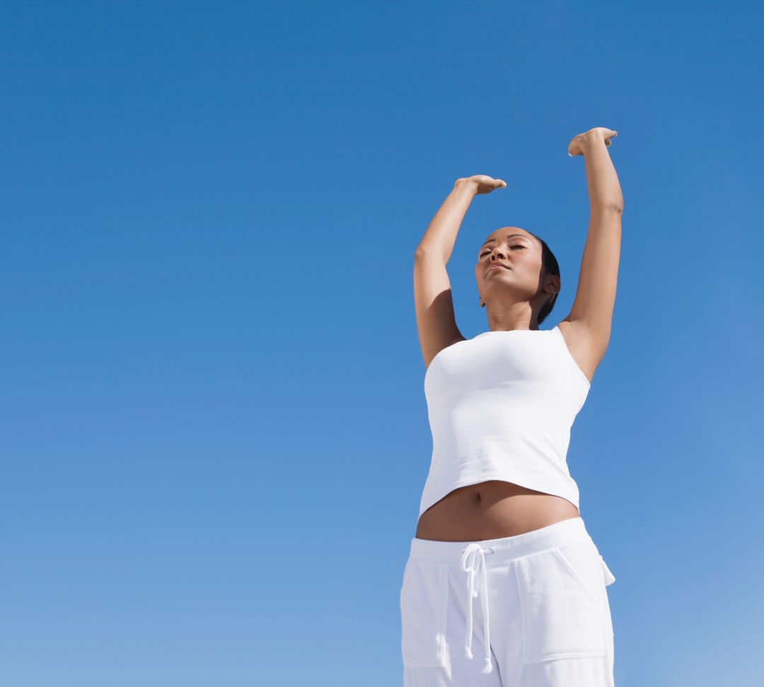 Woman Doing Yoga in Front of a Blue Sky
