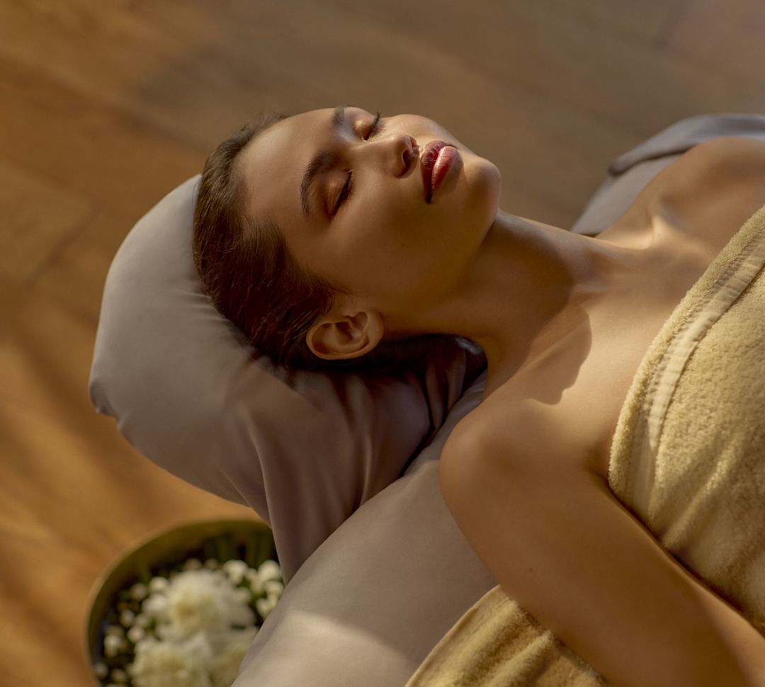 Woman in towel relaxing on spa treatment table