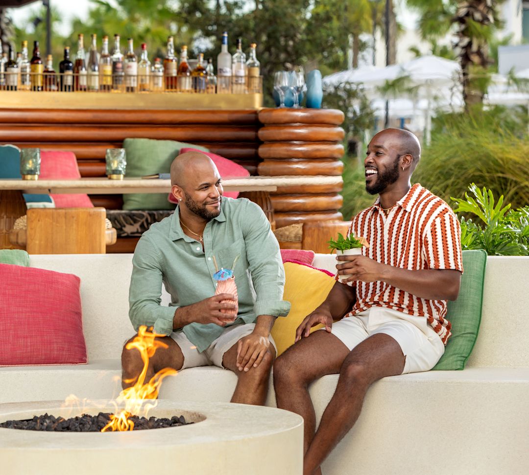 guests having a drink by the fire pit at Papaya Club-transition
