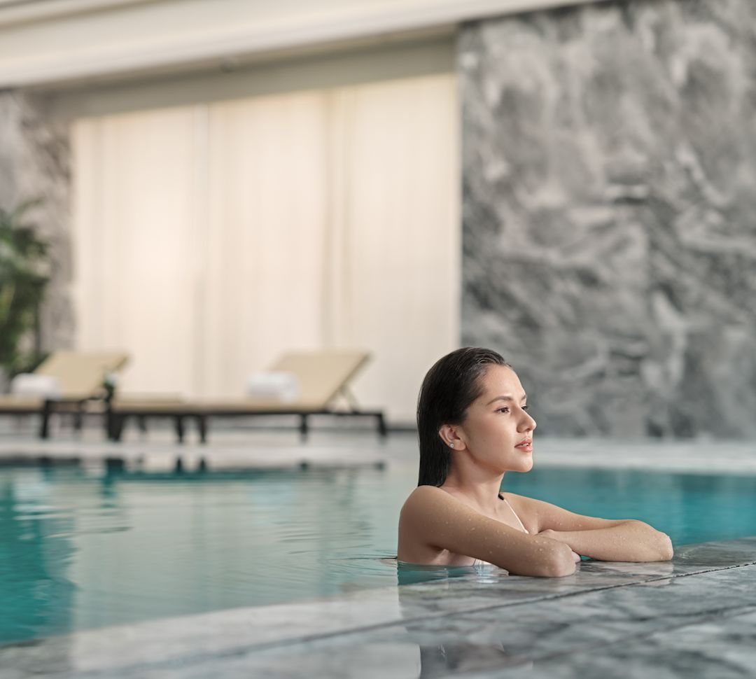 在室内泳池边放松身心的女士