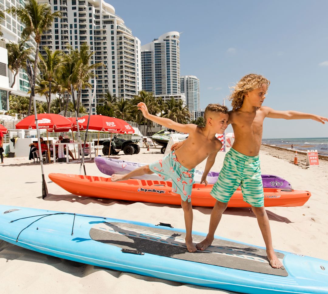 plajda sörf tahtasında çocuklar