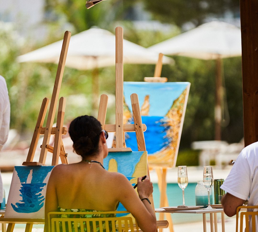 Frauen malen draußen am Swimmingpool