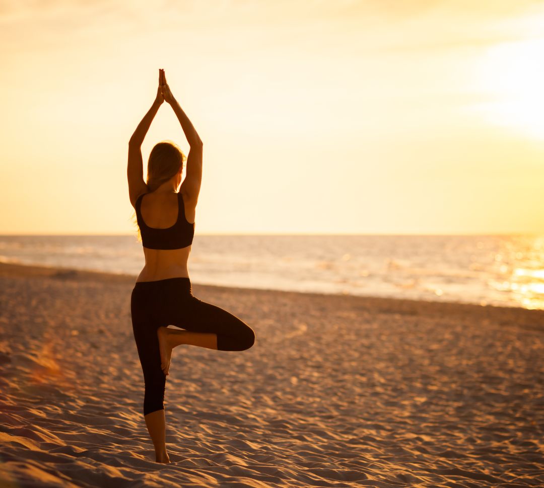 Woman doing yoga on beach