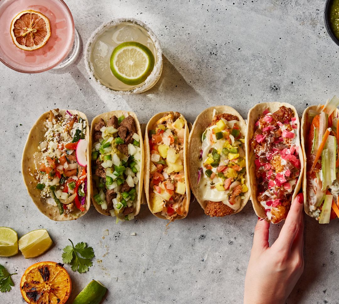 Nahaufnahme von Tacos mit Drinks und Beilagensaucen