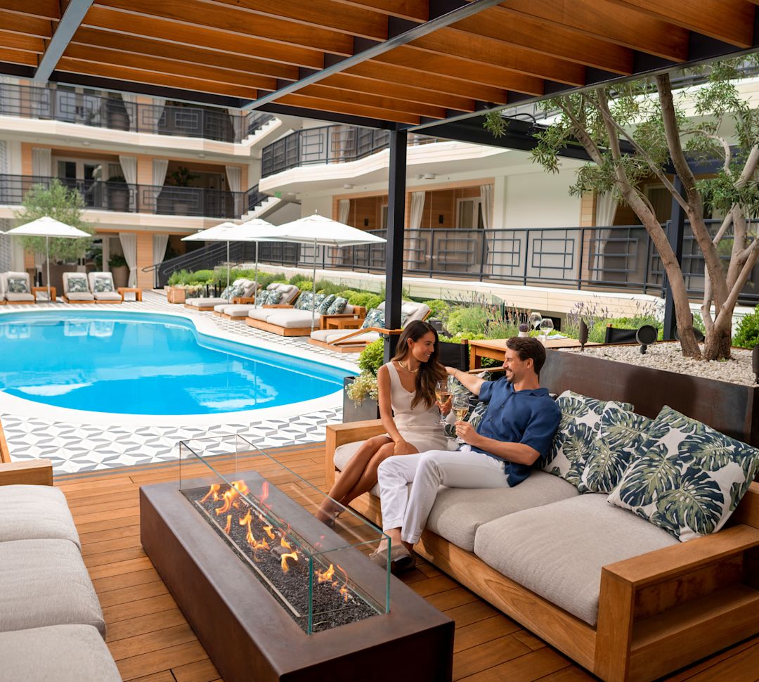 Alternative Aufnahme eines Paares, das neben dem Poolwechsel unter der Cabana sitzt