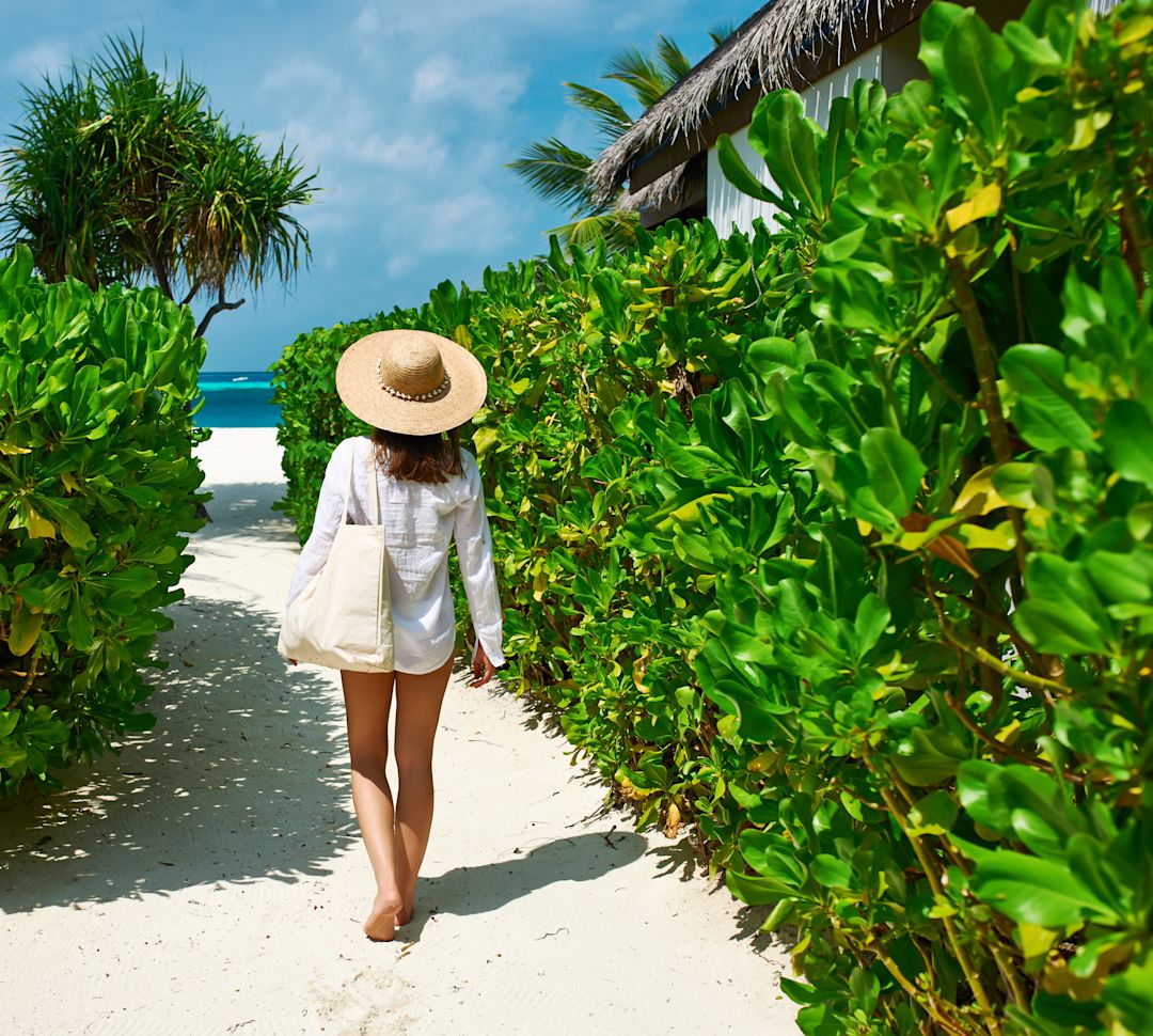 Femme marchant sur un chemin menant à la plage