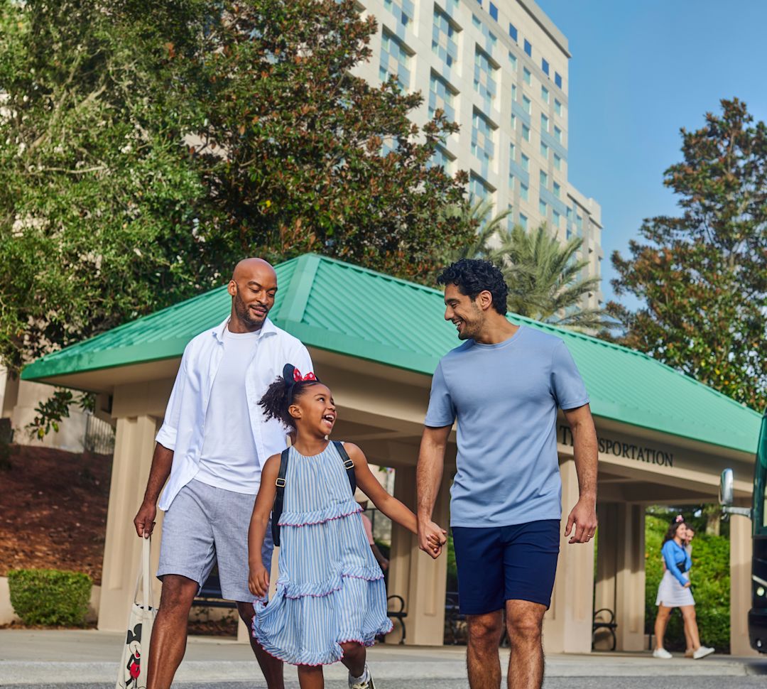 Dois homens e uma menina andando de mãos dadas