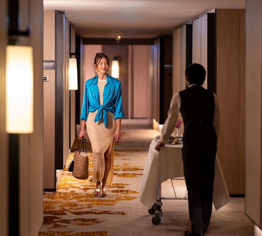 Oaspete al hotelului mergând pe hol, pe lângă transferul angajatului