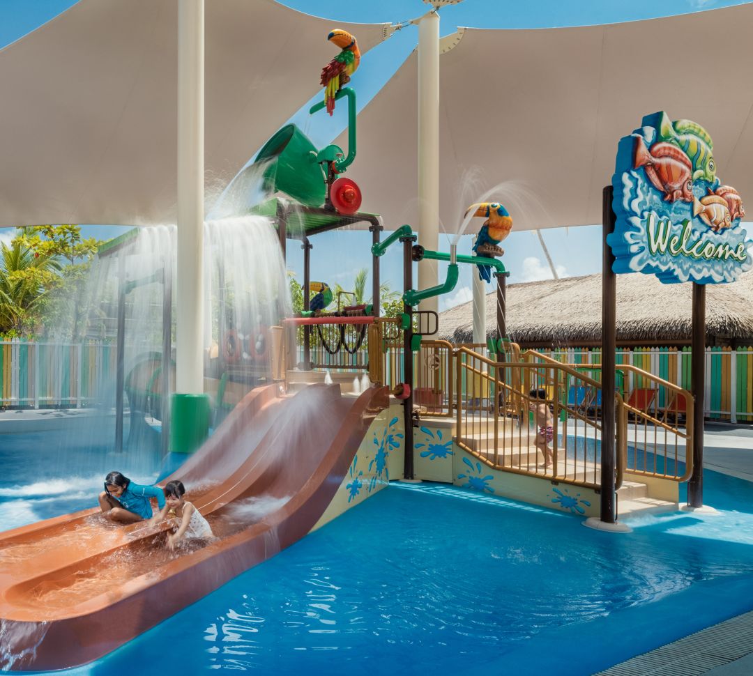 Pool area with children playing on water slides