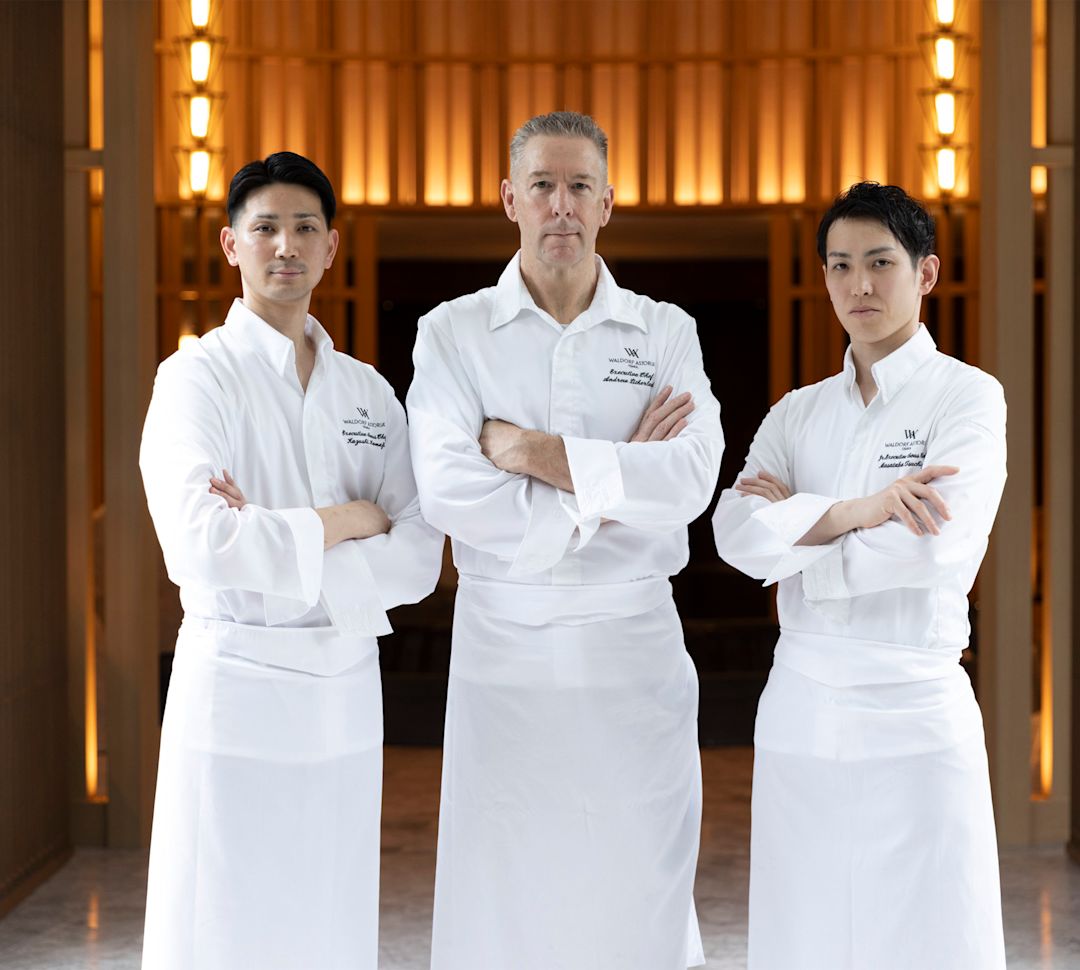 白いシェフのコートを着て立つ3人のシェフ。- トランション