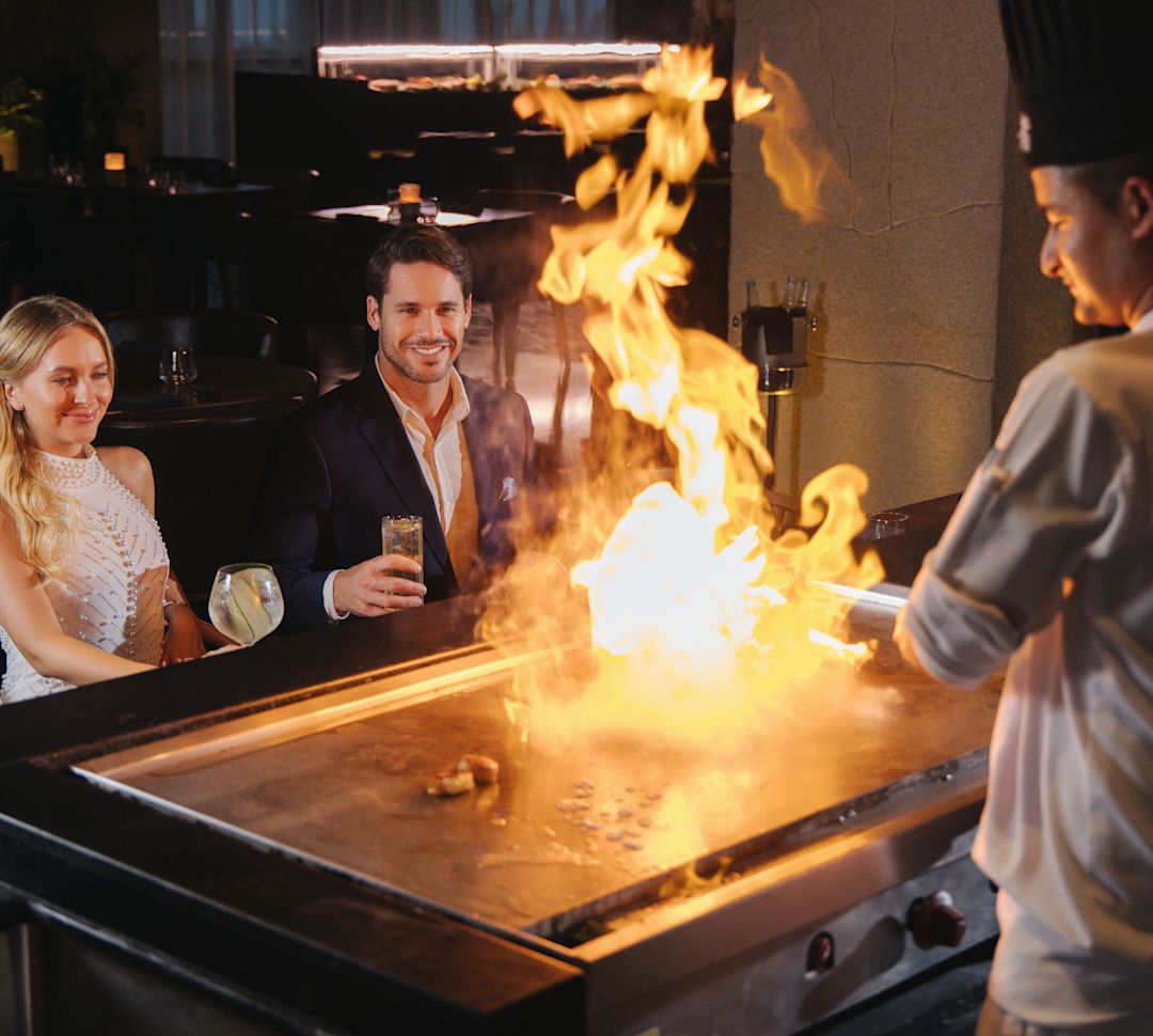Couple Enjoying Watching a Chef Cooking on a Teppanyaki at UMI Restaurant