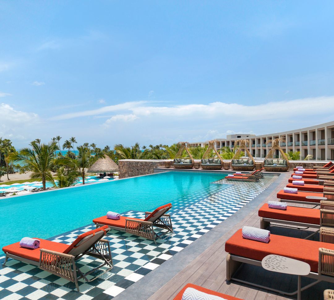 Piscina de borde infinito con disposición de sillas