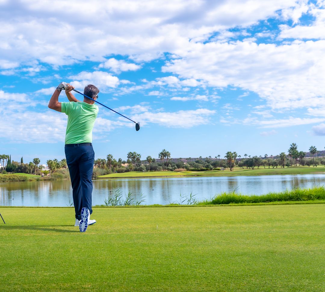A person playing golf on a sunny day. 