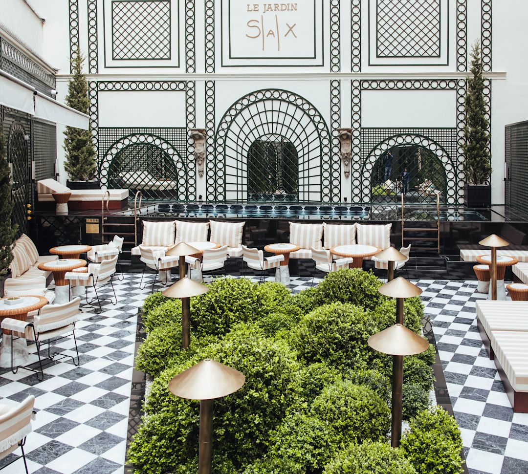 Tables, chaises et bancs dans un restaurant avec de la végétation