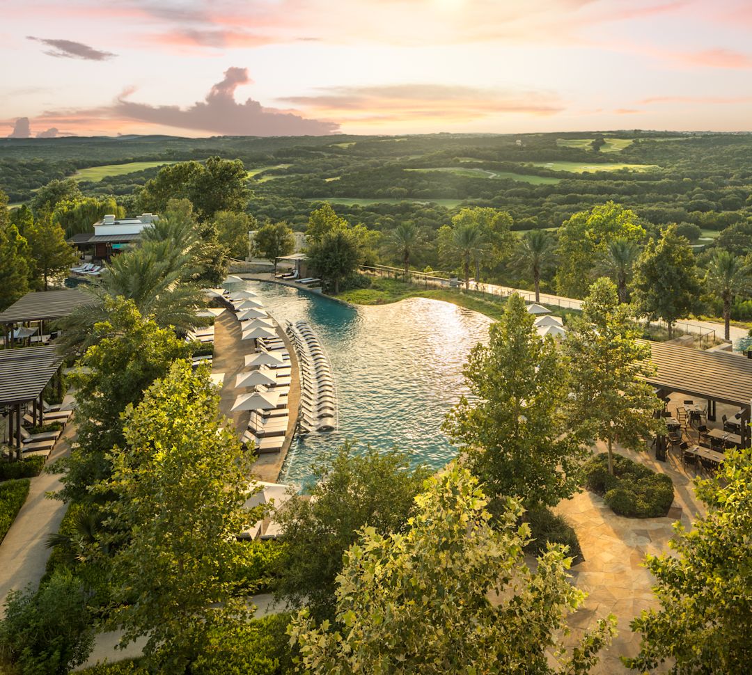 酒店外观，设有户外泳池、躺椅和树木