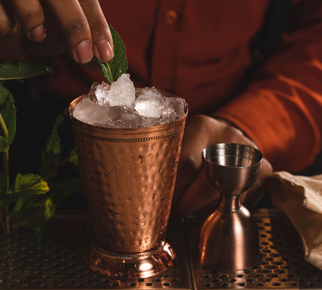 bartender making a cocktail in a copper cup