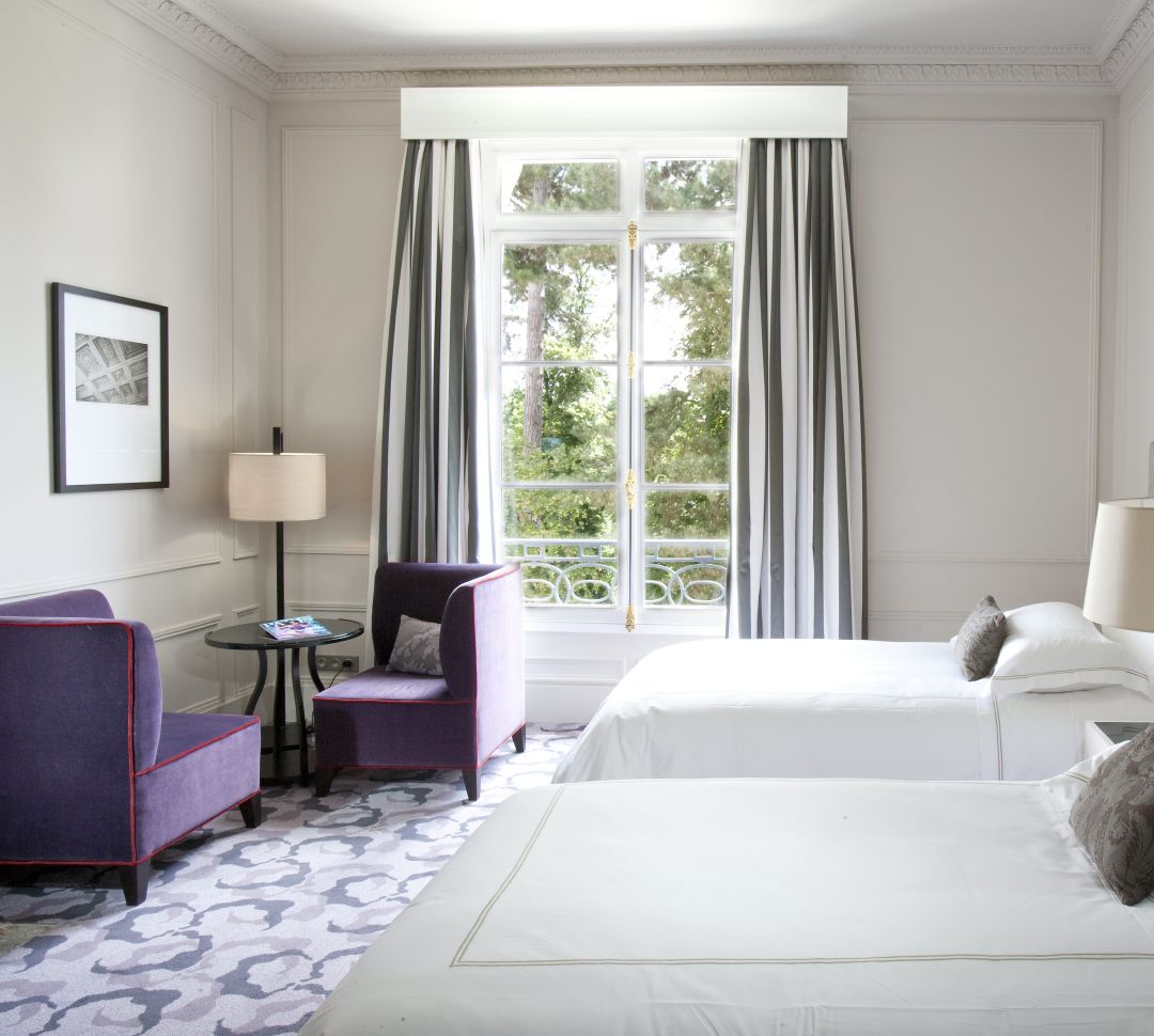 Zwei Betten im Hotelzimmer mit Sitzbereich und Gartenblick