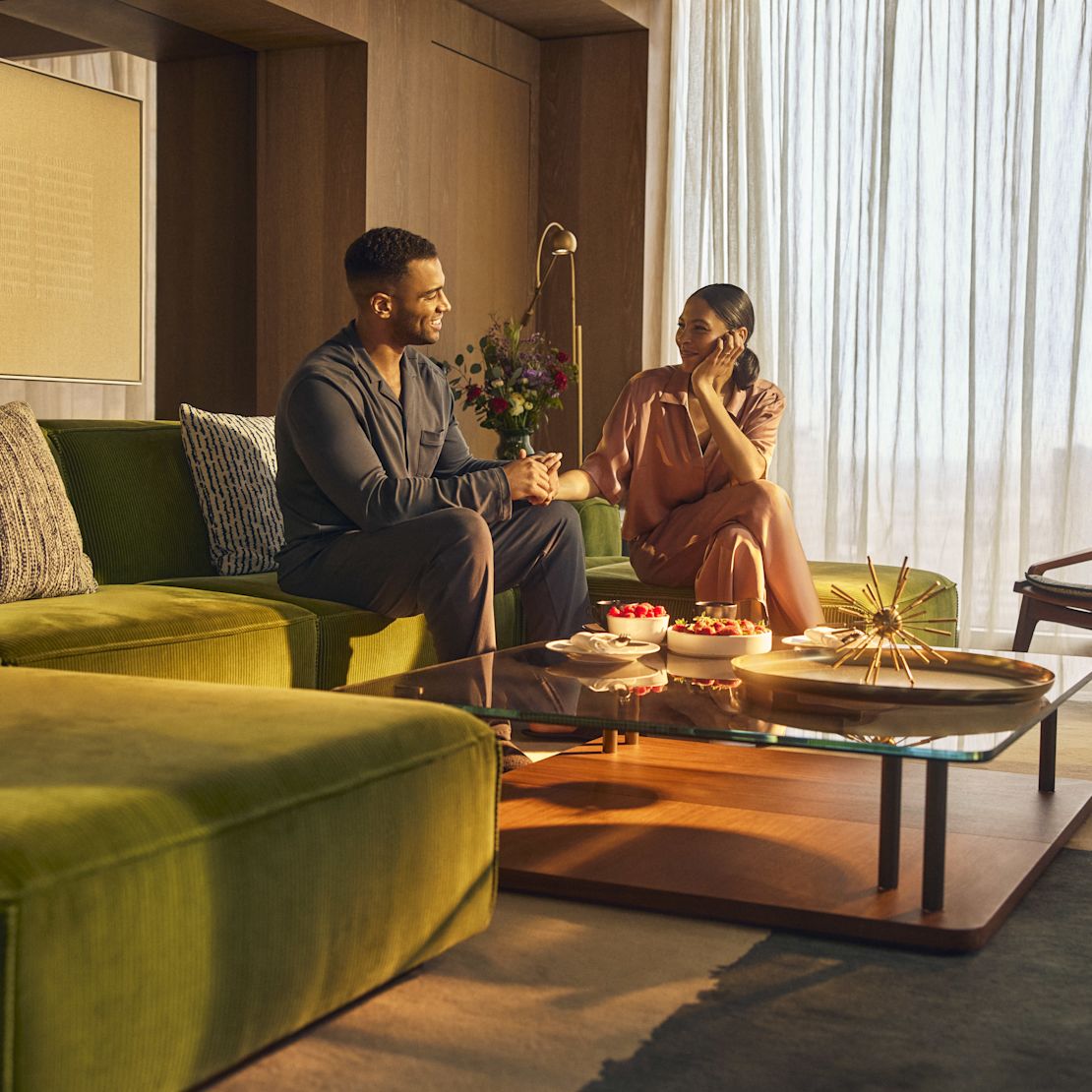 Man and woman relaxing in comfortable seating area with table and chairs-transition