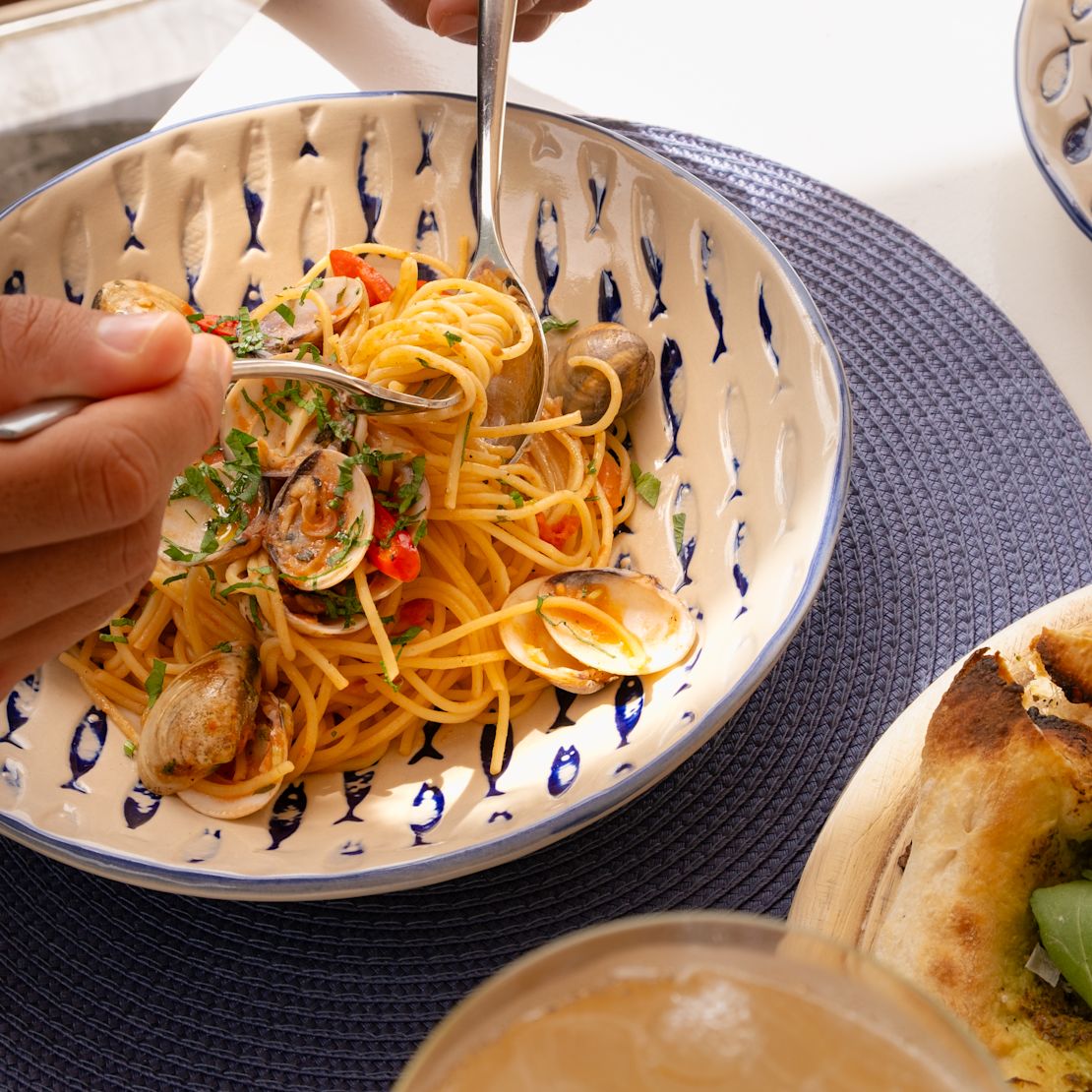 Person Dining Seafood with Pasta Dish at Azure Restaurant-transition