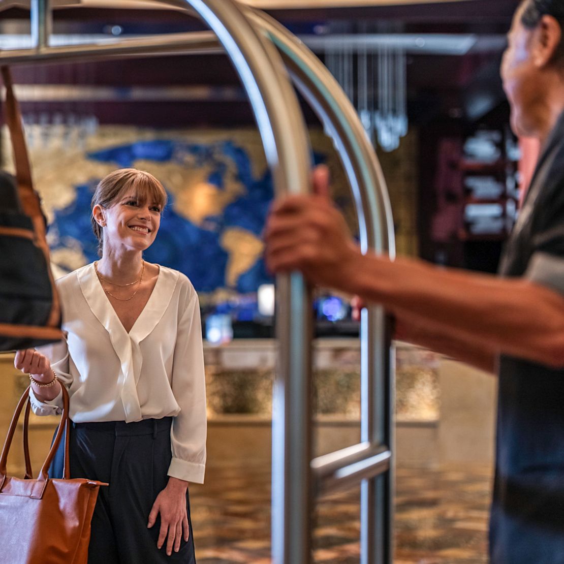 O femeie care sosește la un hotel și un clopoțel o ajută cu tranziția