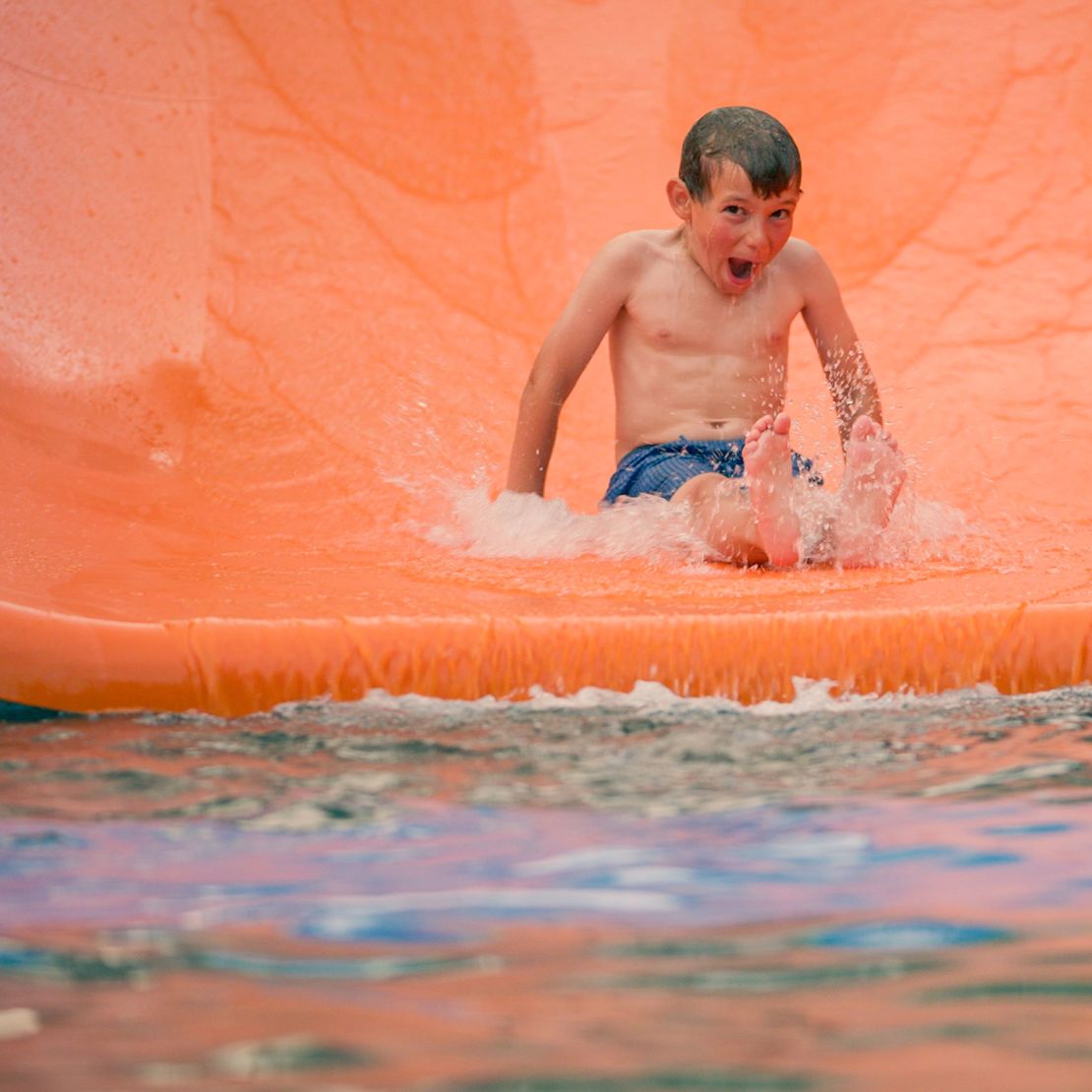 Kid sliding on water slide-transition