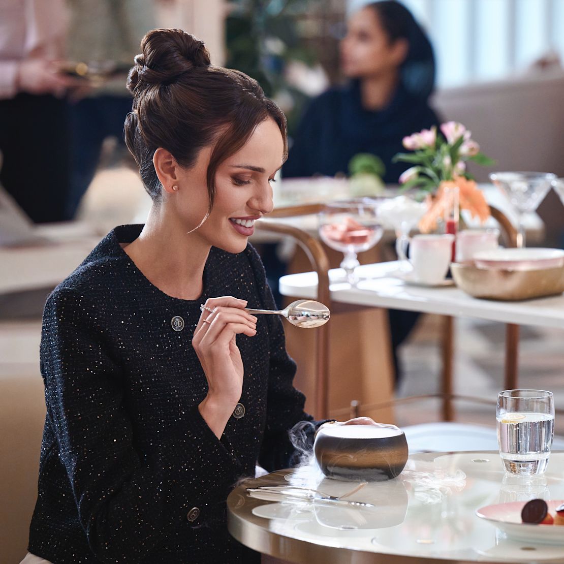 砂漠の移民がテーブルに腰掛けて微笑む女性