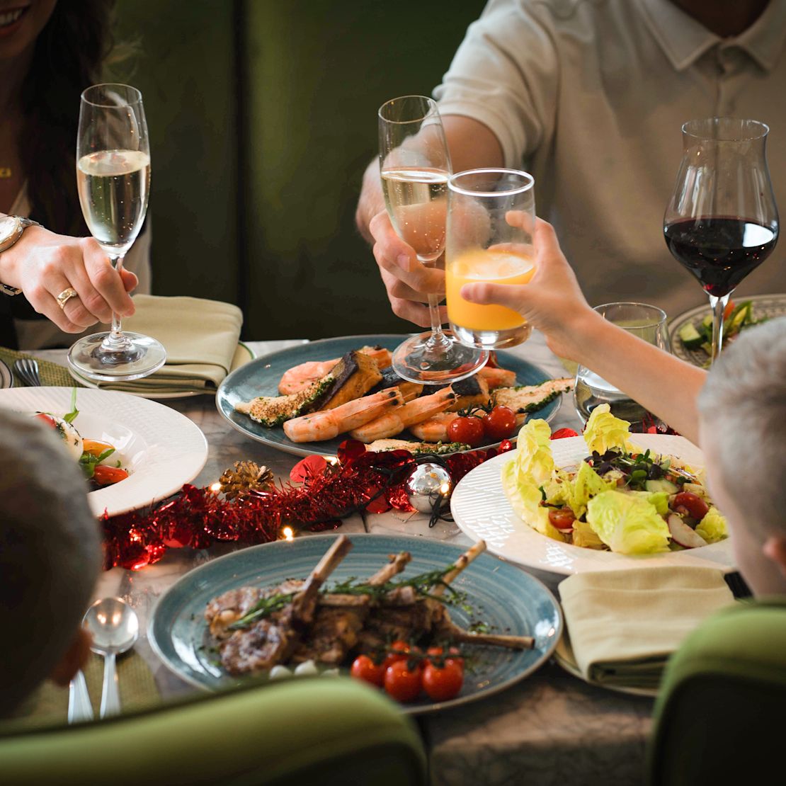 Qasr Al Bahar restaurant with group of people raising glass in toast over selection of food-transition
