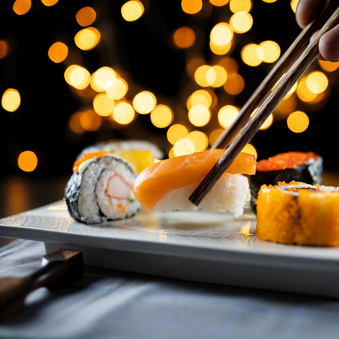 Person Getting a Piece of Sushi on a Plate at UMI Restaurant-transition