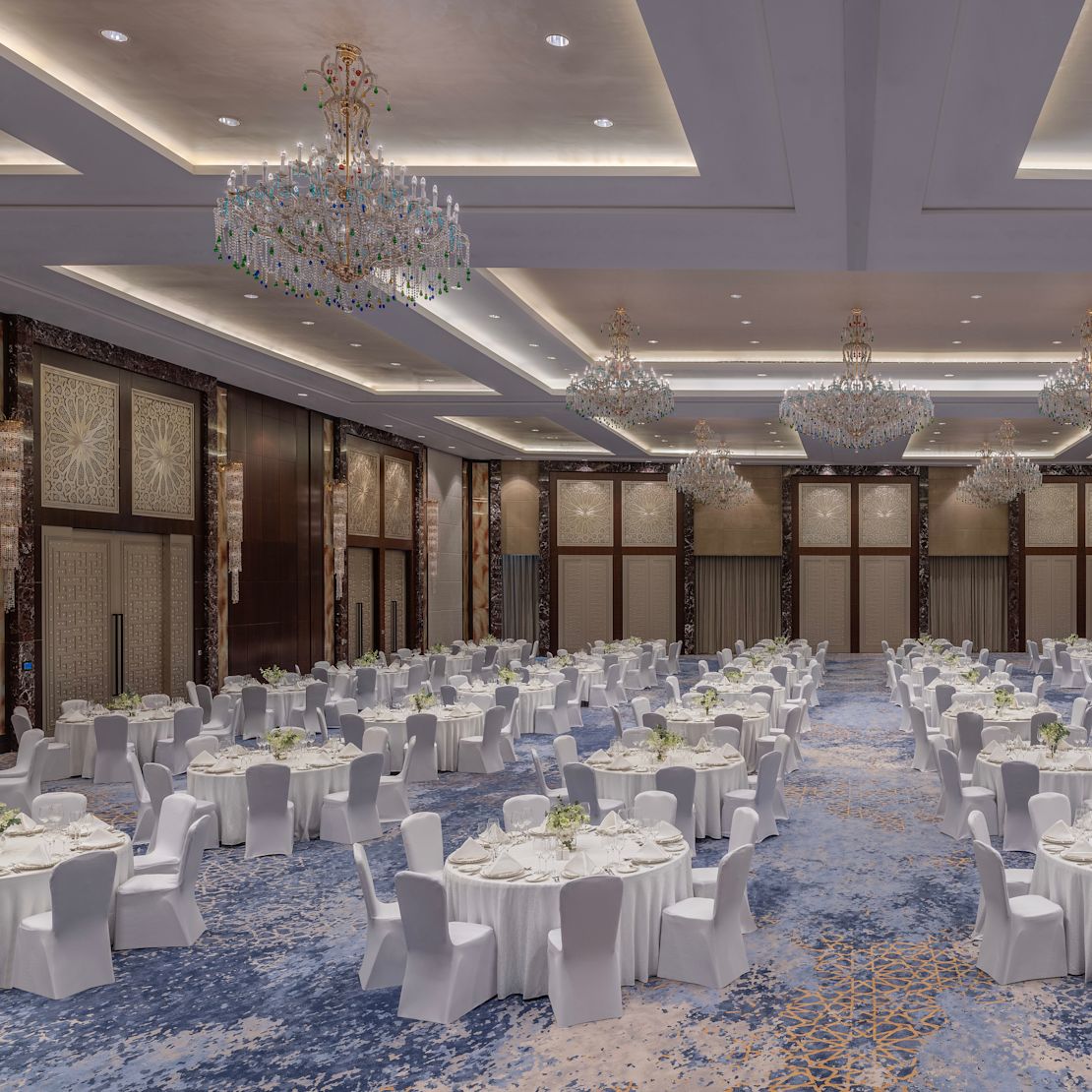 Gala večeře v nastavení velkého tanečního sálu s kulatými stoly – přechod