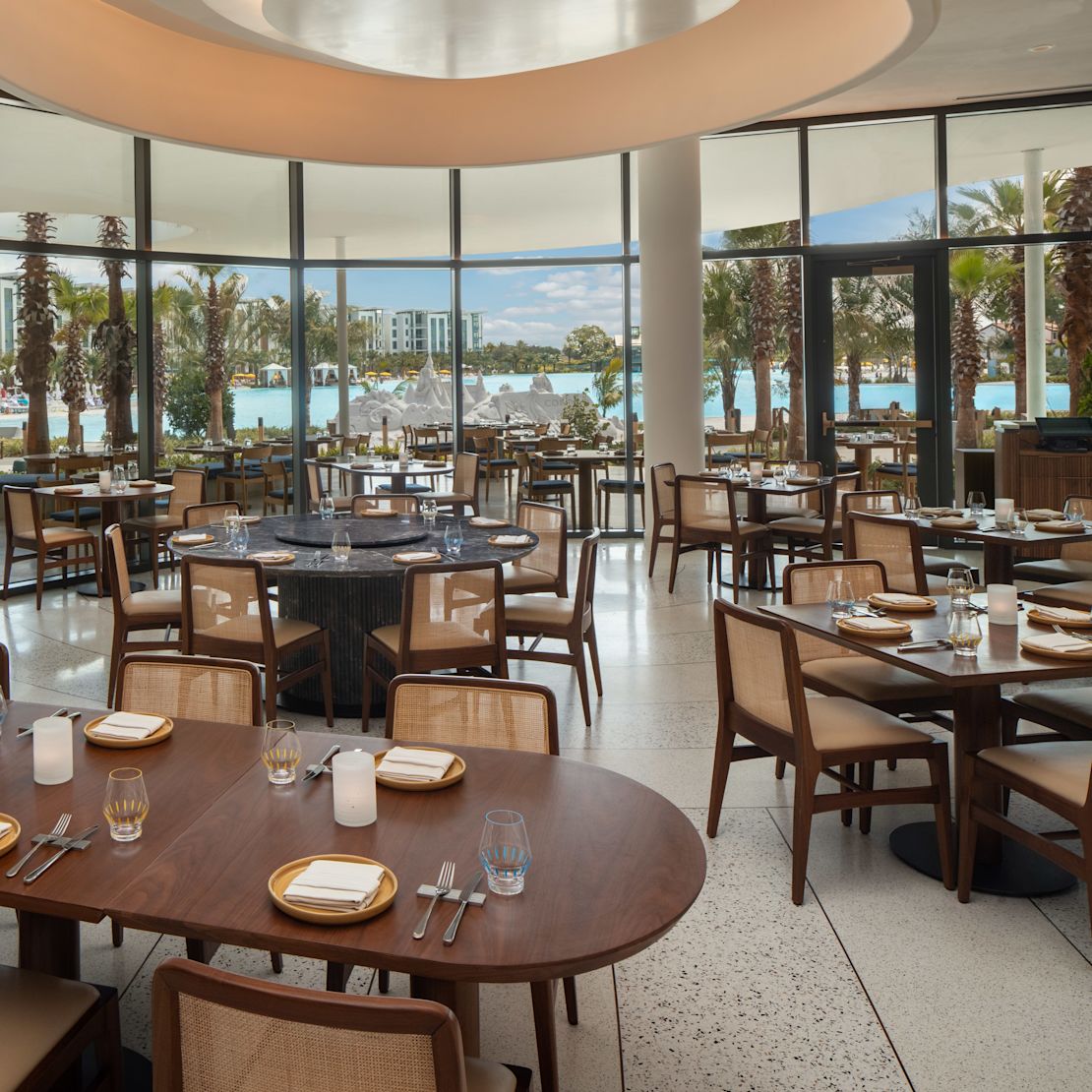 Essbereich des Restaurants "Sophias" mit Panoramafenstern und hellblauem Wasser.-Übergang