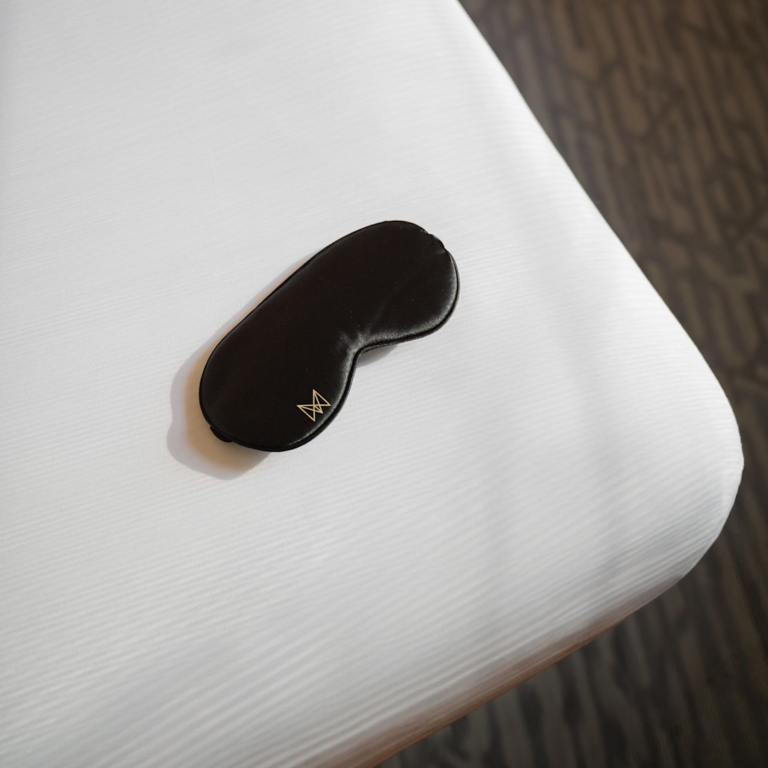 Black Sleep Mask on a Bed-transition
