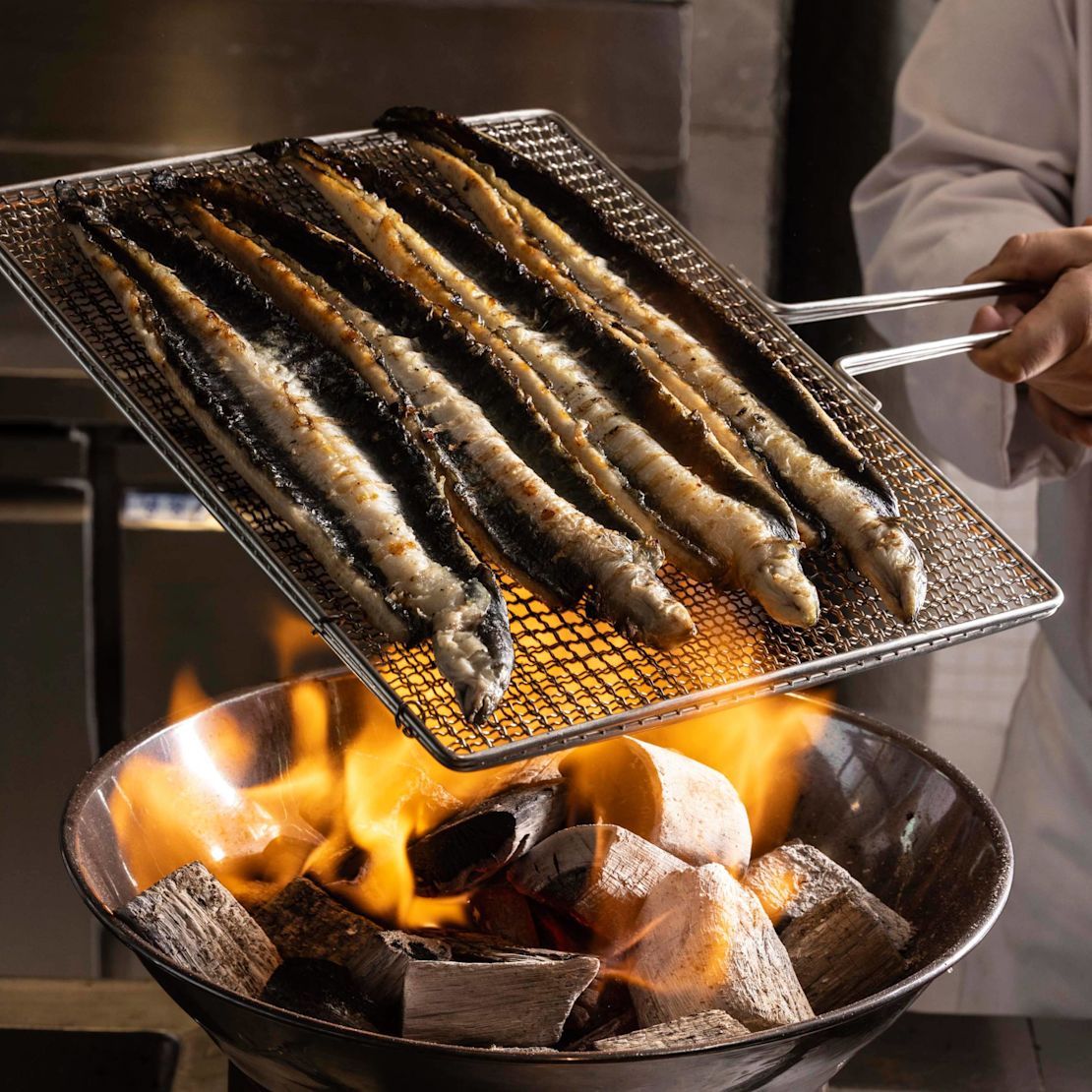 Un chef asa pescado en una transición a la parrilla