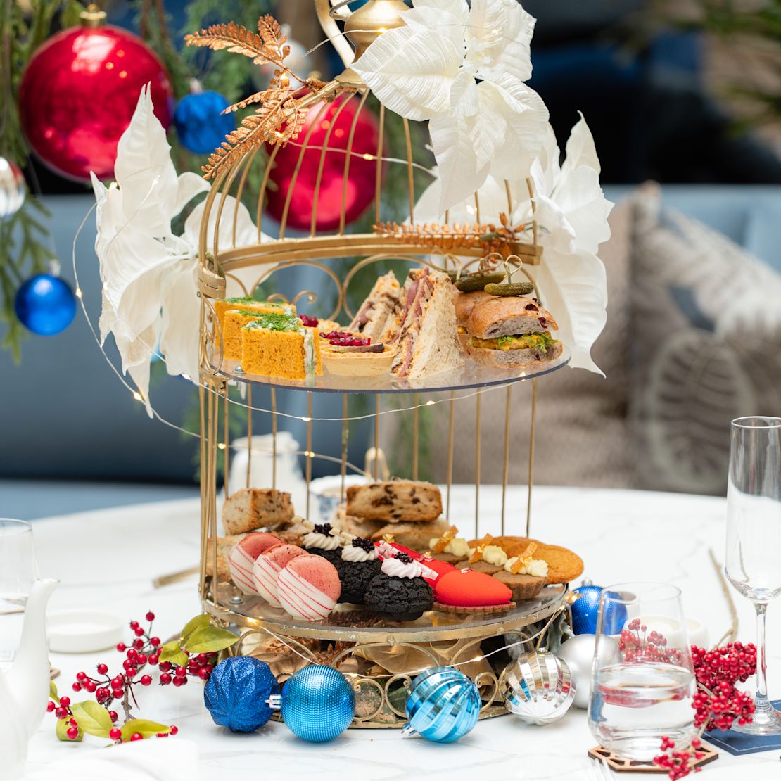 Exhibición del té de la tarde de las fiestas en Peacock Alley, sándwiches, galletas, adornos de las fiestas-transición