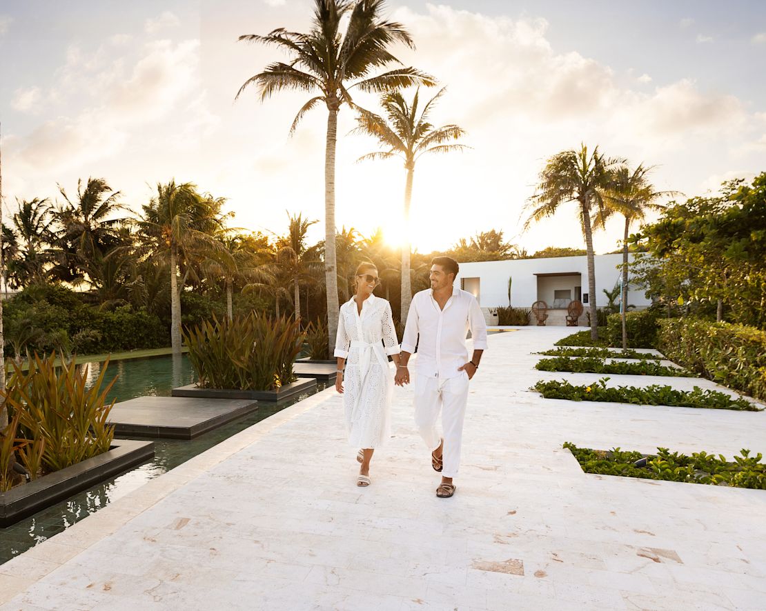 couple marchant dans le jardin/la cour de l'hôtel