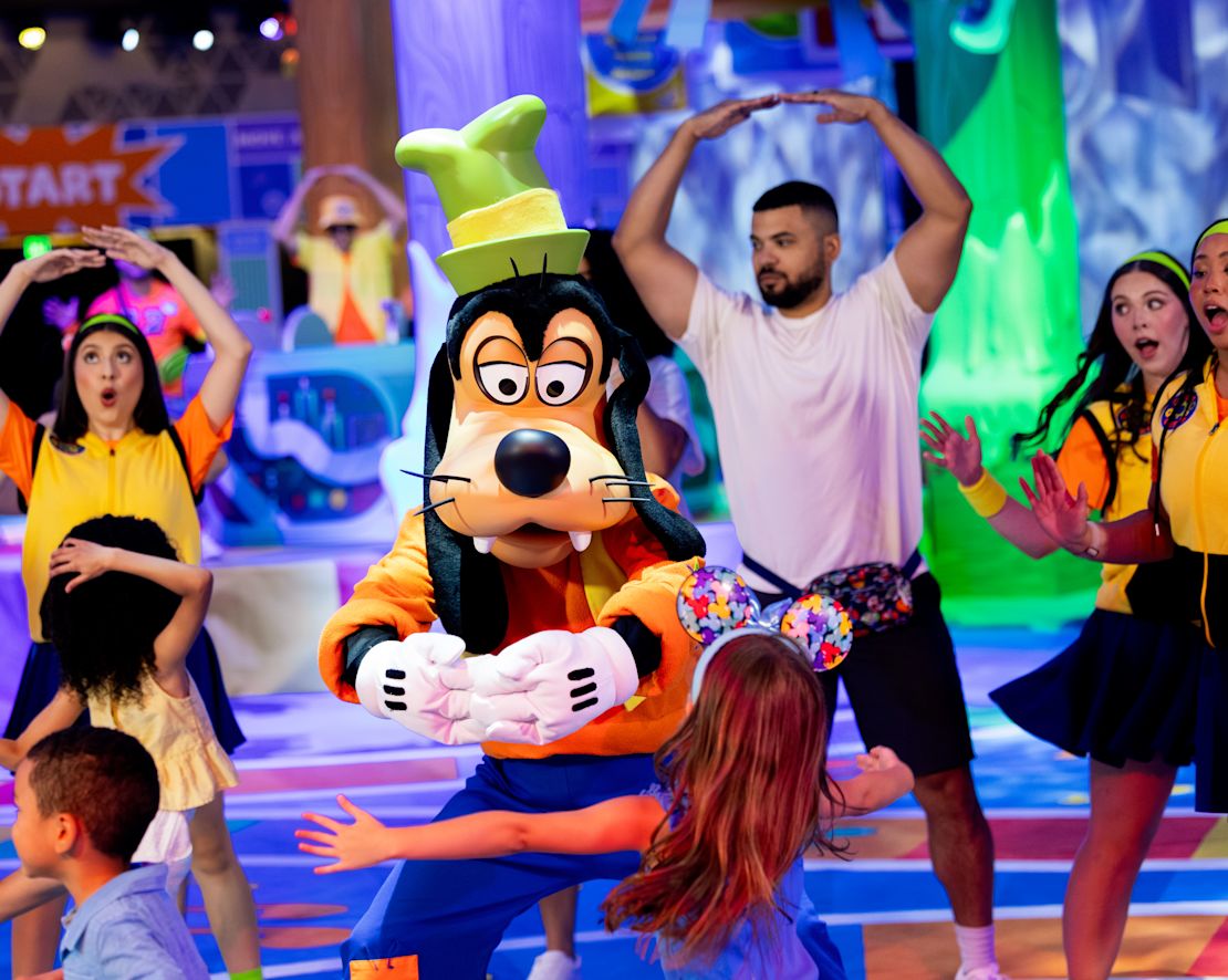 Gente disfrutando de un espectáculo de perros de Goofy en Disney World-transition