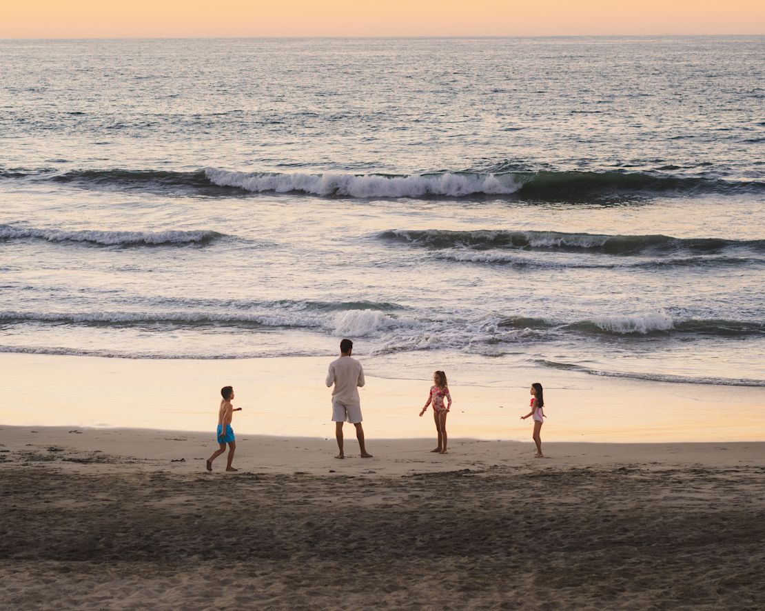 Familj som står på strandövergång